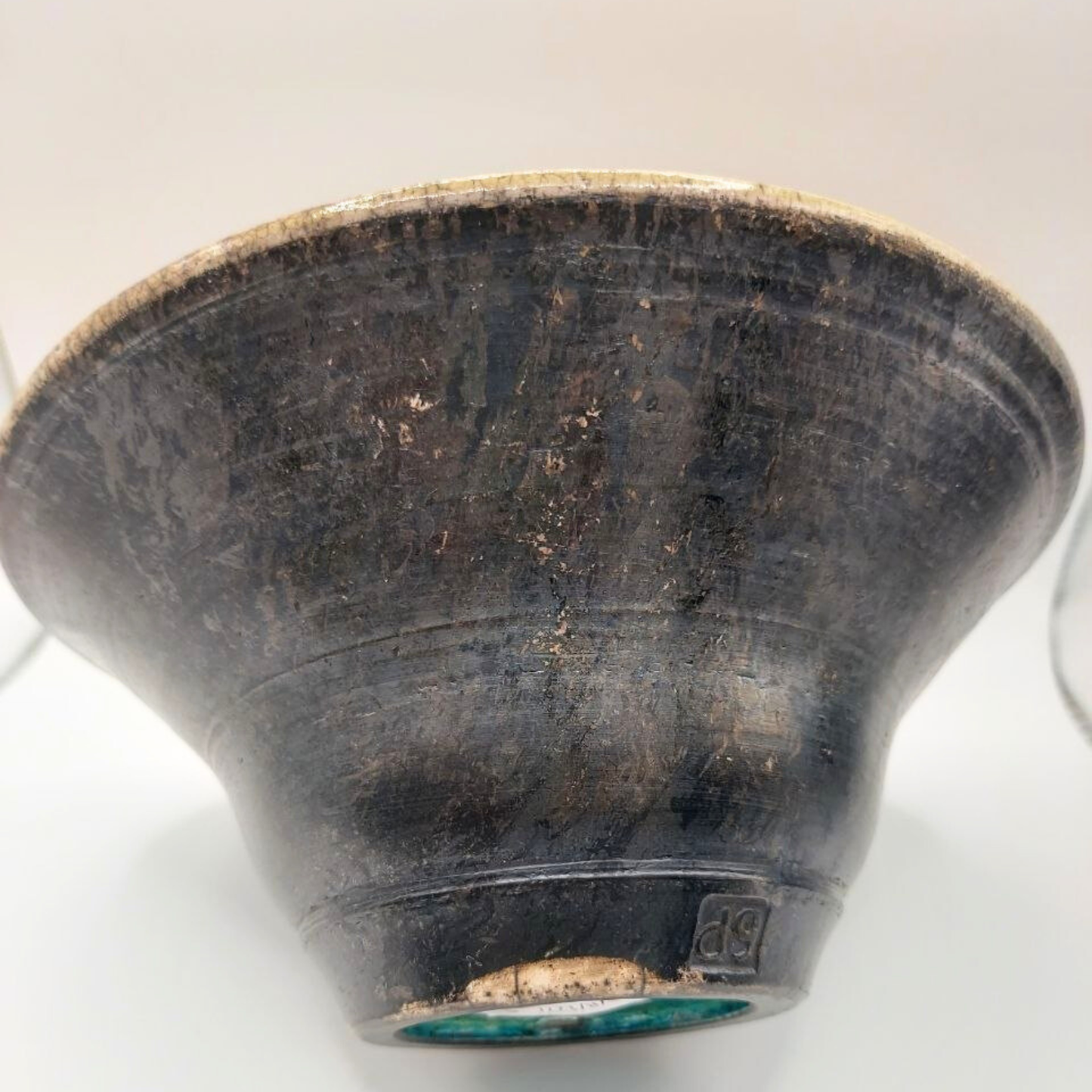 Black ceramic bowl with visible wear on a white background