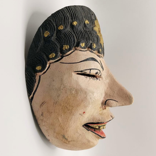 Wooden mask with detailed facial features and black hair on a white background