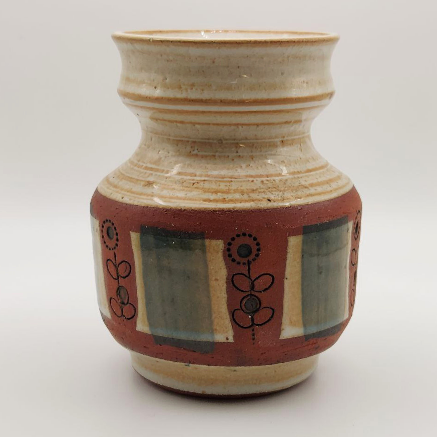 Ceramic vase with flowery and rectangular patterns on a white background