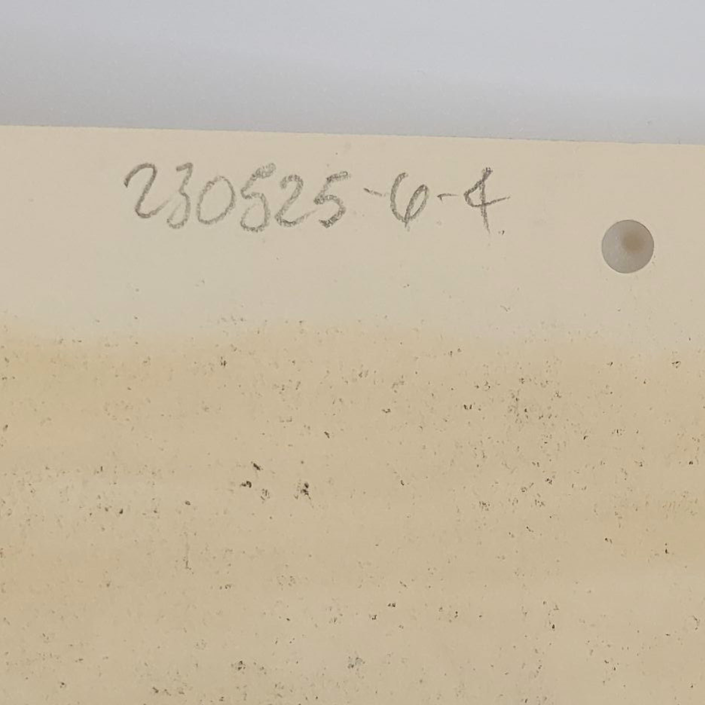 Beige art paper with a number and letter code on a white background