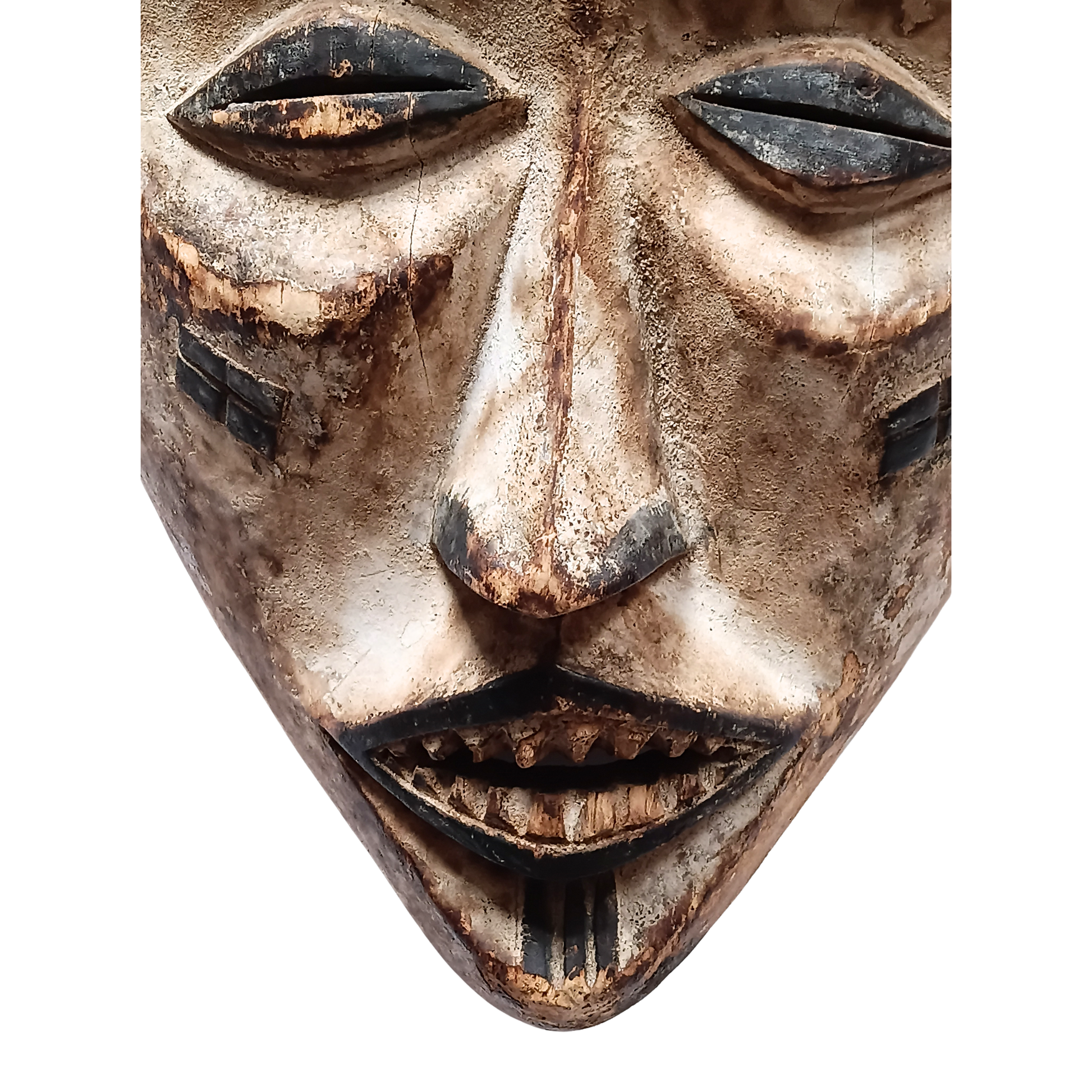 A close-up of a carved wooden mask with a weathered, textured finish in shades of beige, brown, and black, set against a plain white background.