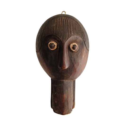 A dark brown carved wooden African-style spoon with a hanging loop at the top, shown against a plain white background.