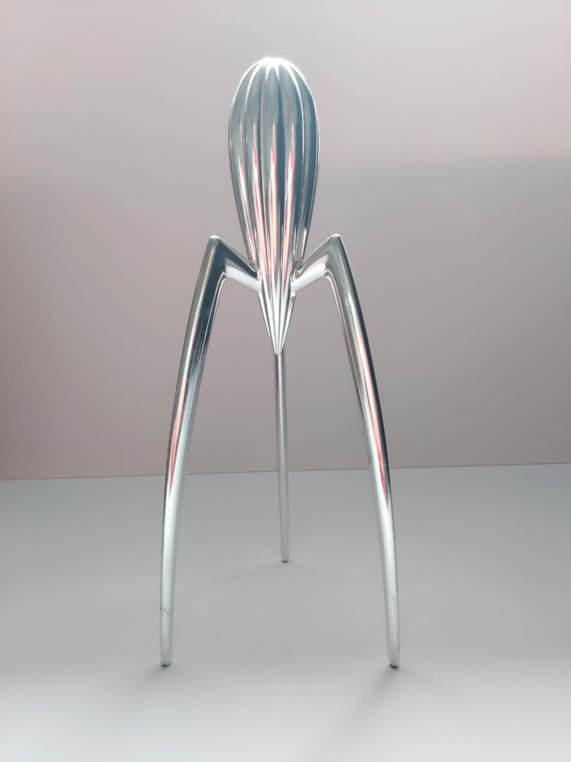 Metallic lemon squeezer with a unique design on a plain background