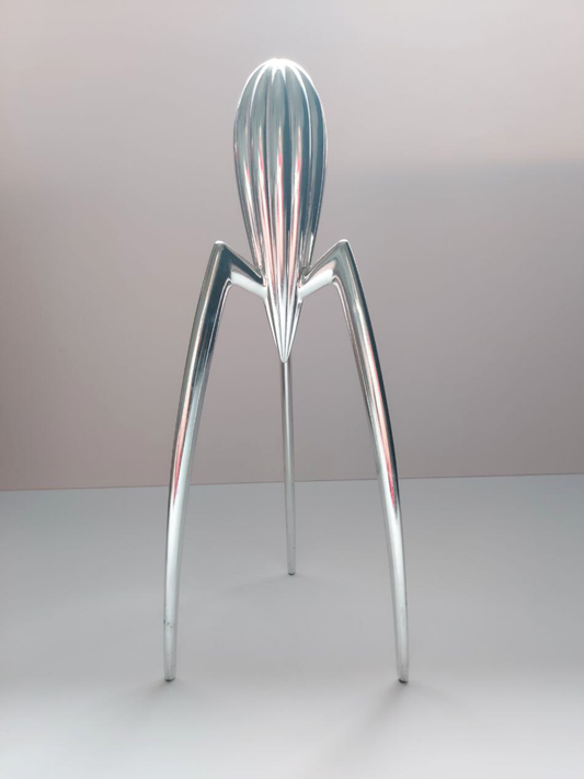 Metallic lemon squeezer with a unique design on a plain background