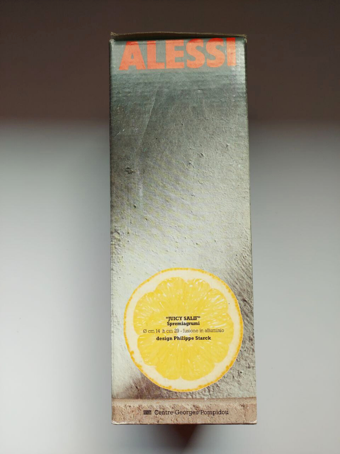 Alessi product packaging with a lemon illustration on a grey background