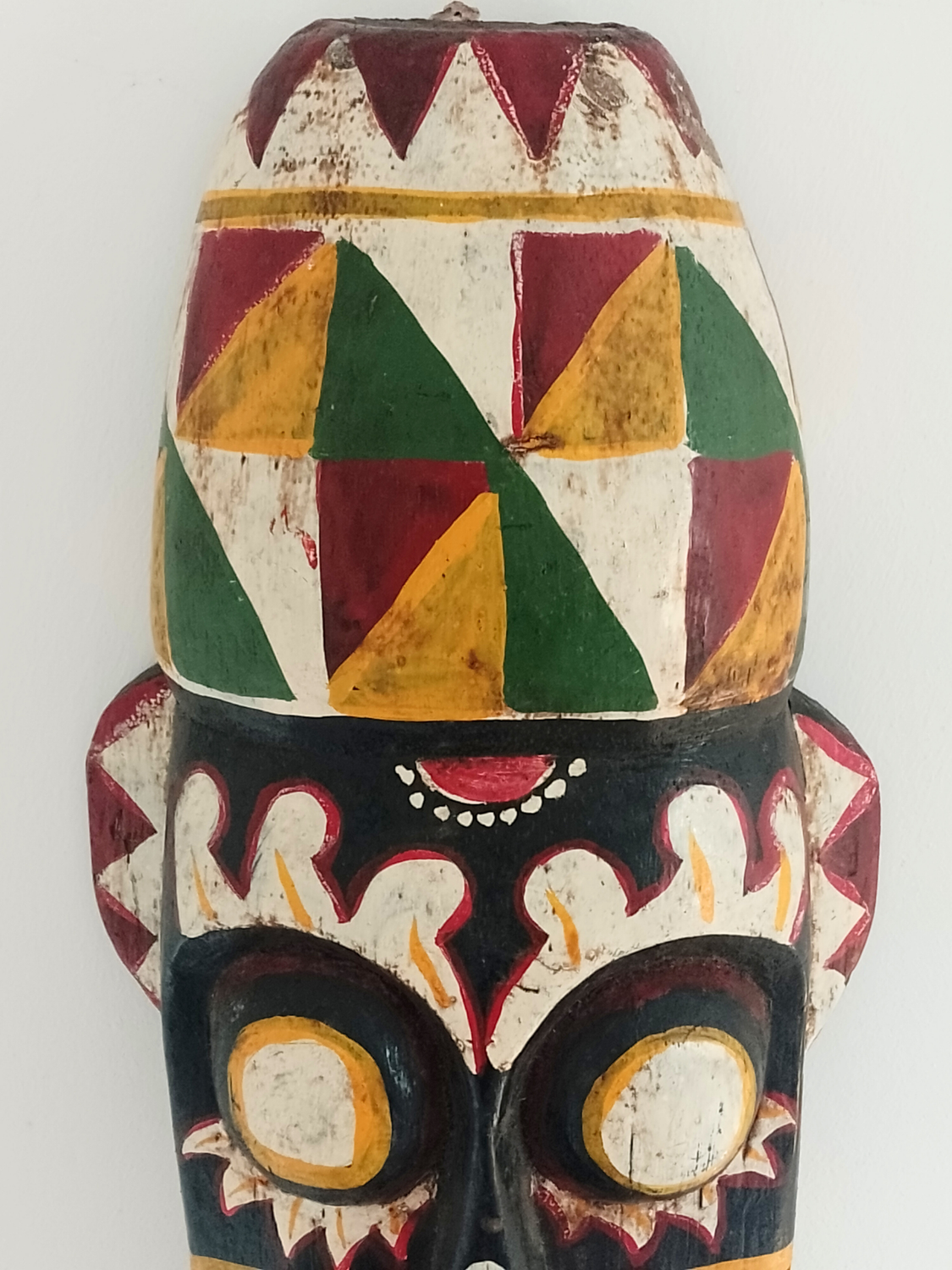 Colorful tribal mask with geometric patterns on a white background