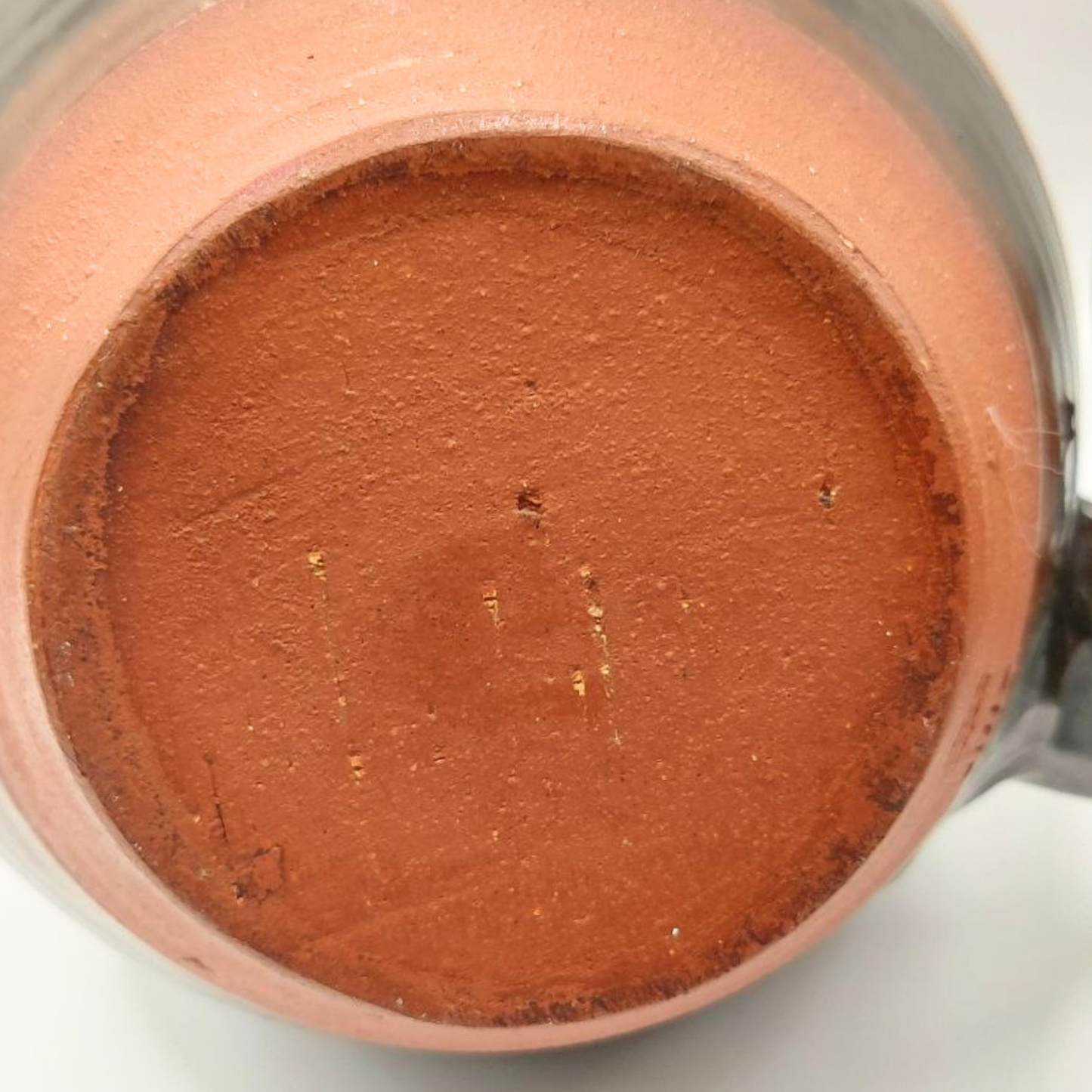 Close-up of the base of a ceramic teapot.