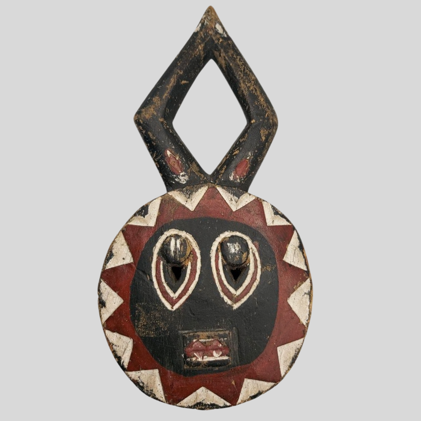 Decorative mask with geometric patterns on a grey background