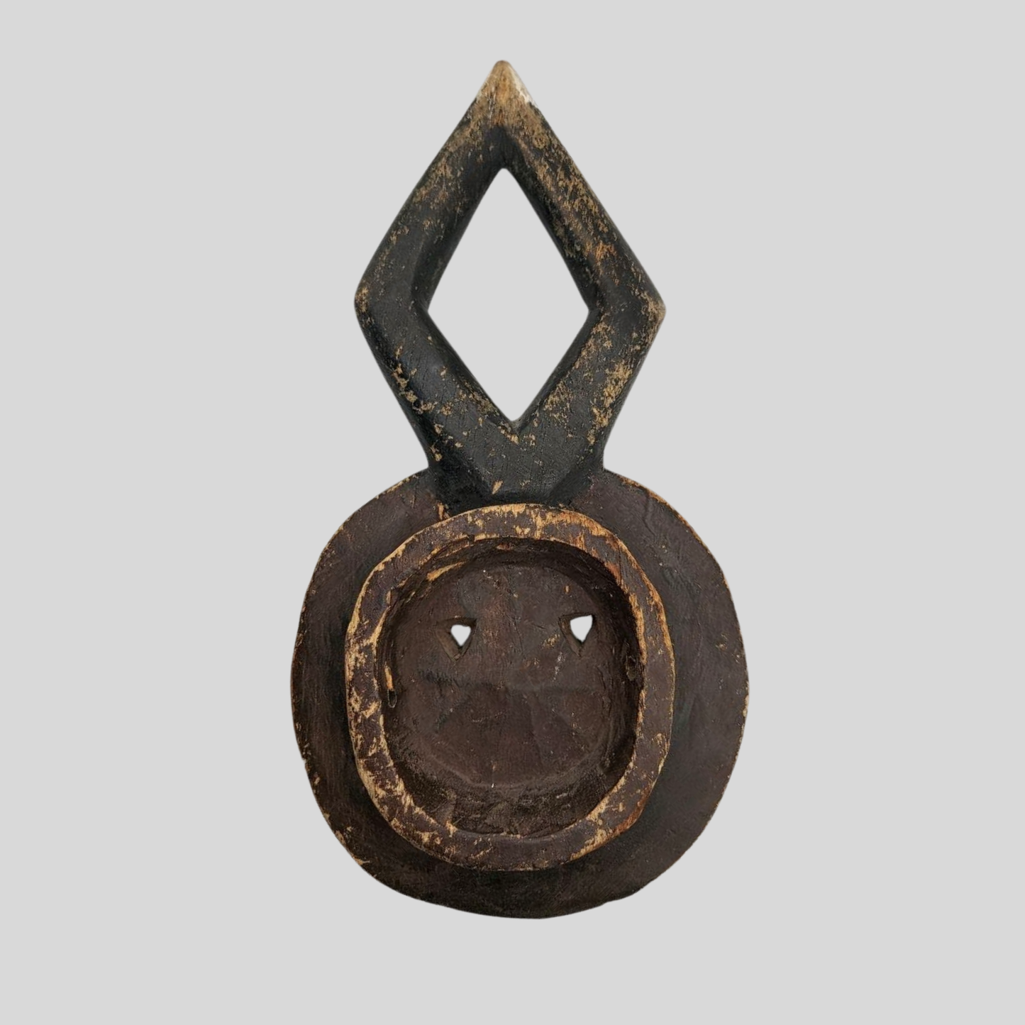 Decorative mask with a diamond-shaped top and circular base on a grey background