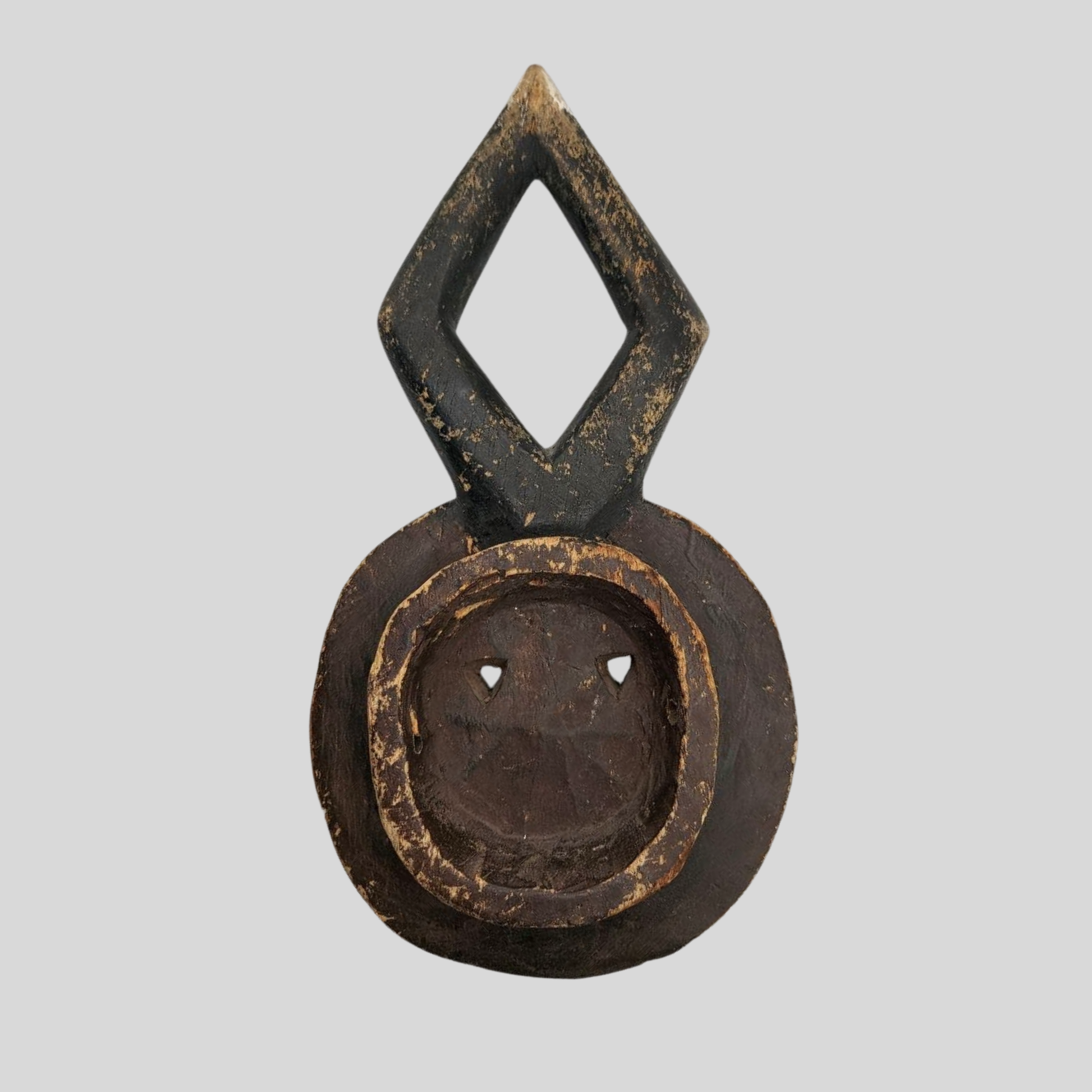 Decorative mask with a diamond-shaped top and circular base on a grey background