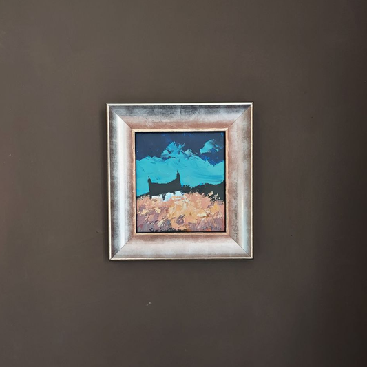 Framed George Somerville artwork of a landscape with mountains and a house on a dark wall.