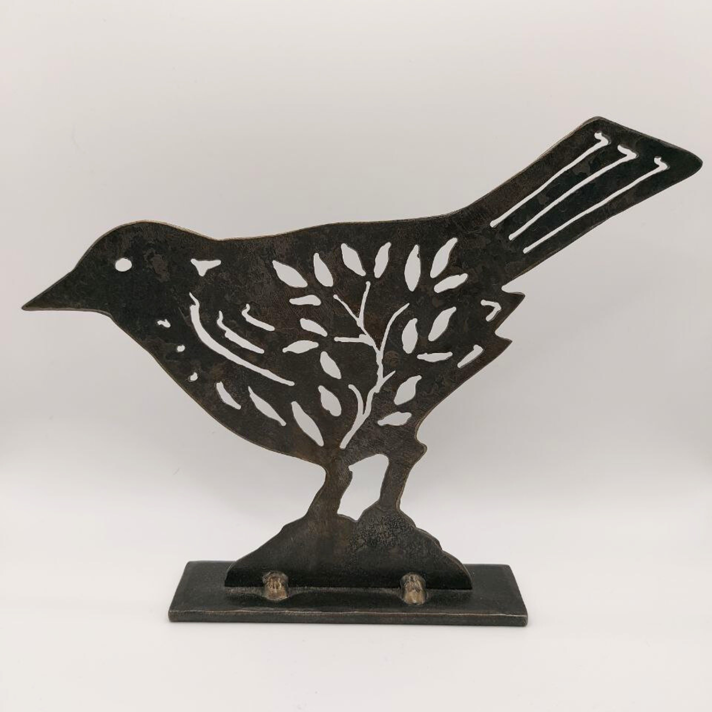 Dark folk art bird sculpture on a white background