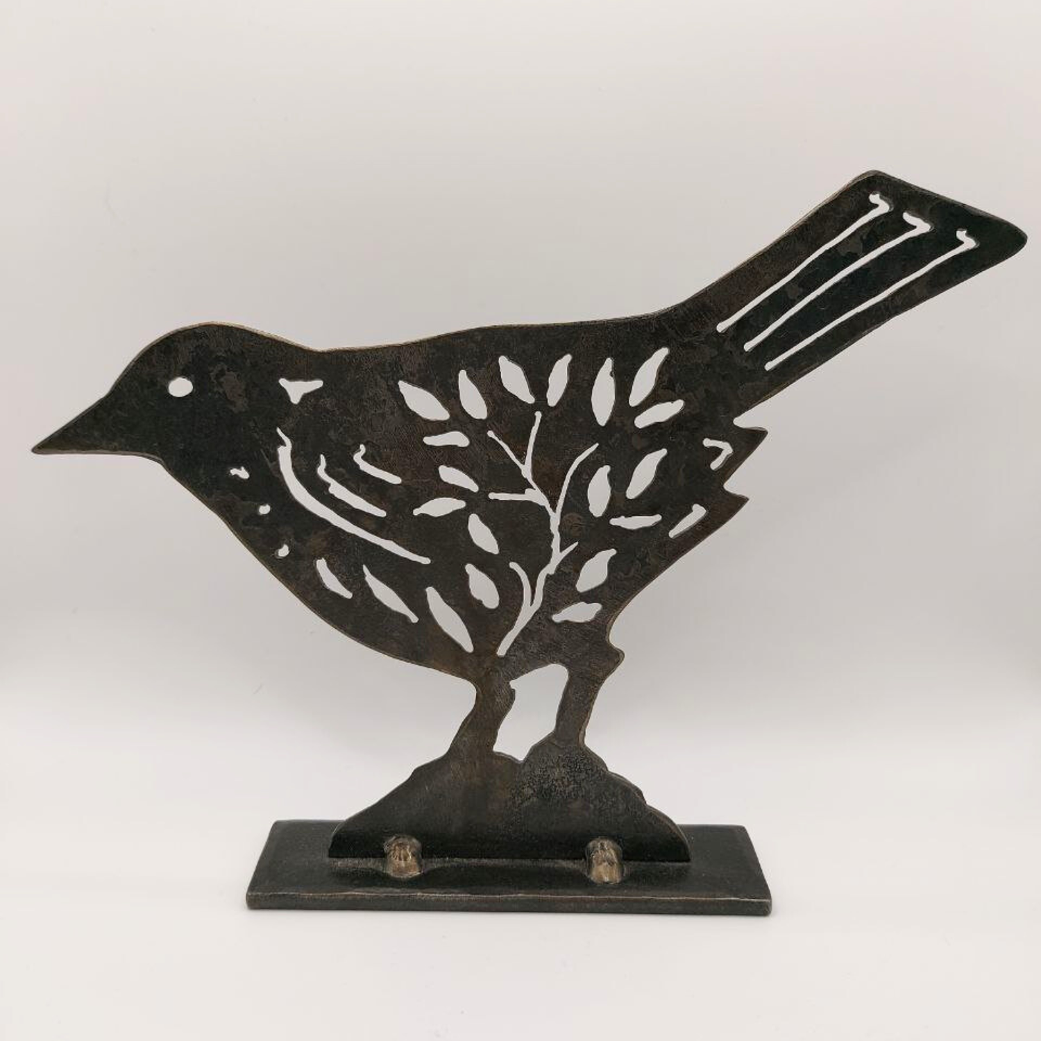 Dark folk art bird sculpture on a white background