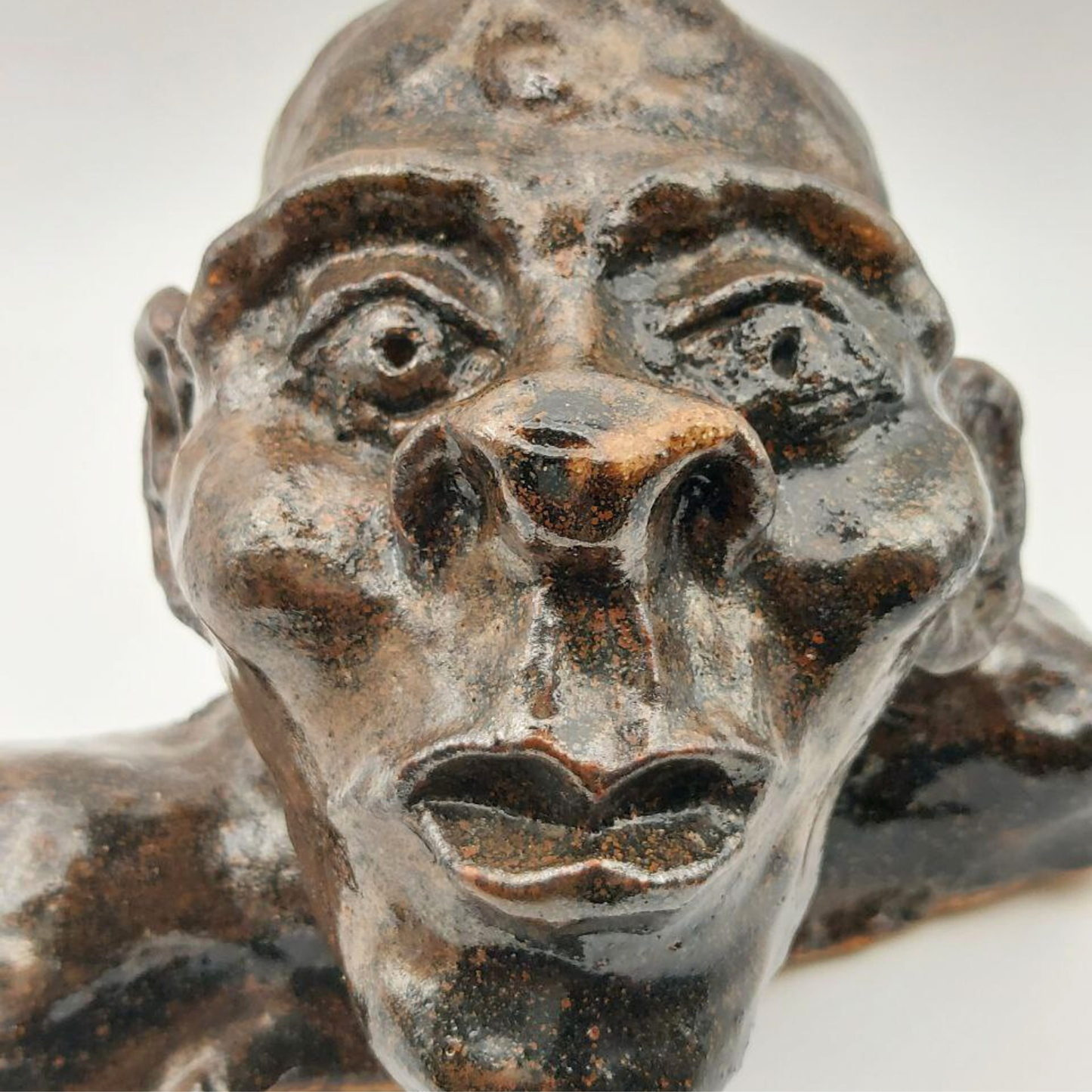 A close-up of a ceramic bust face on a white background