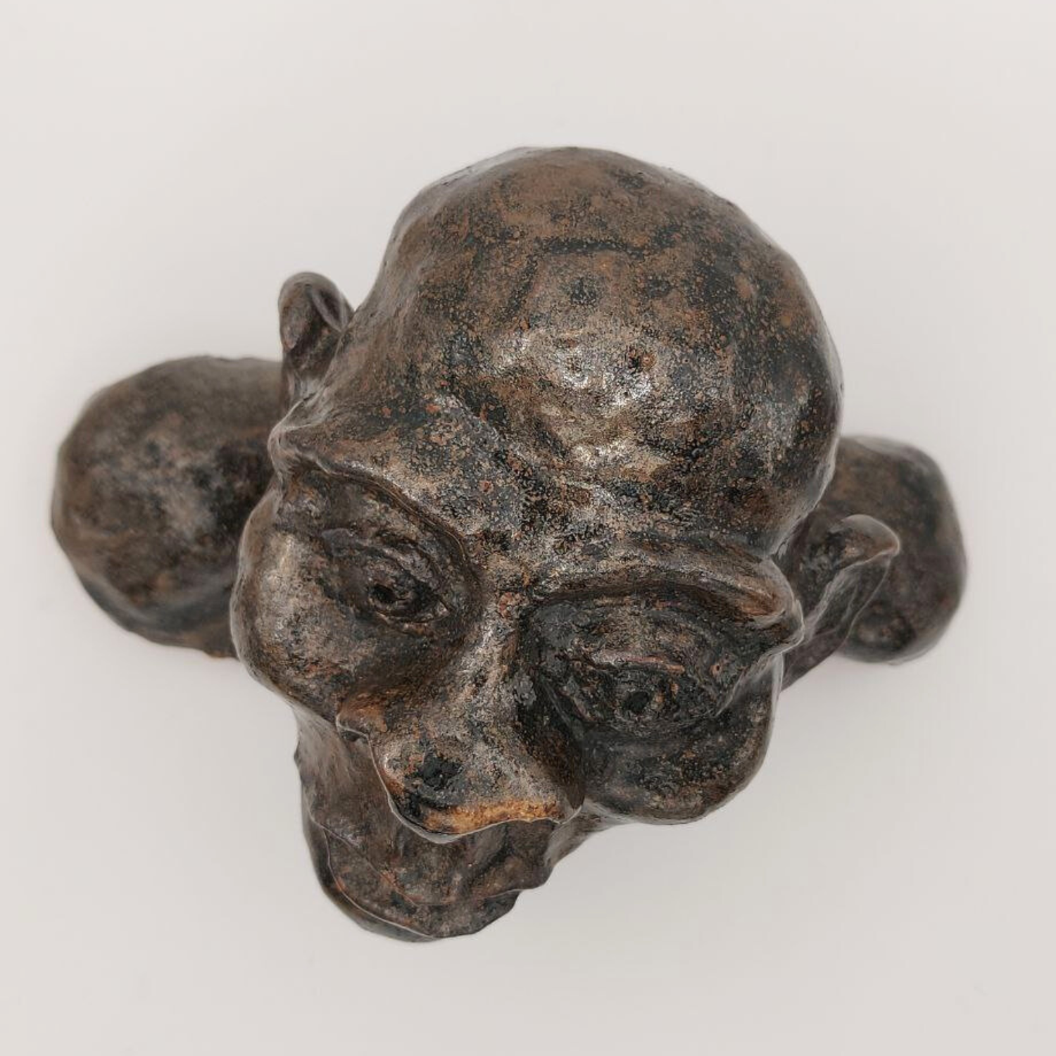 A ceramic bust viewed from above on a white background. 