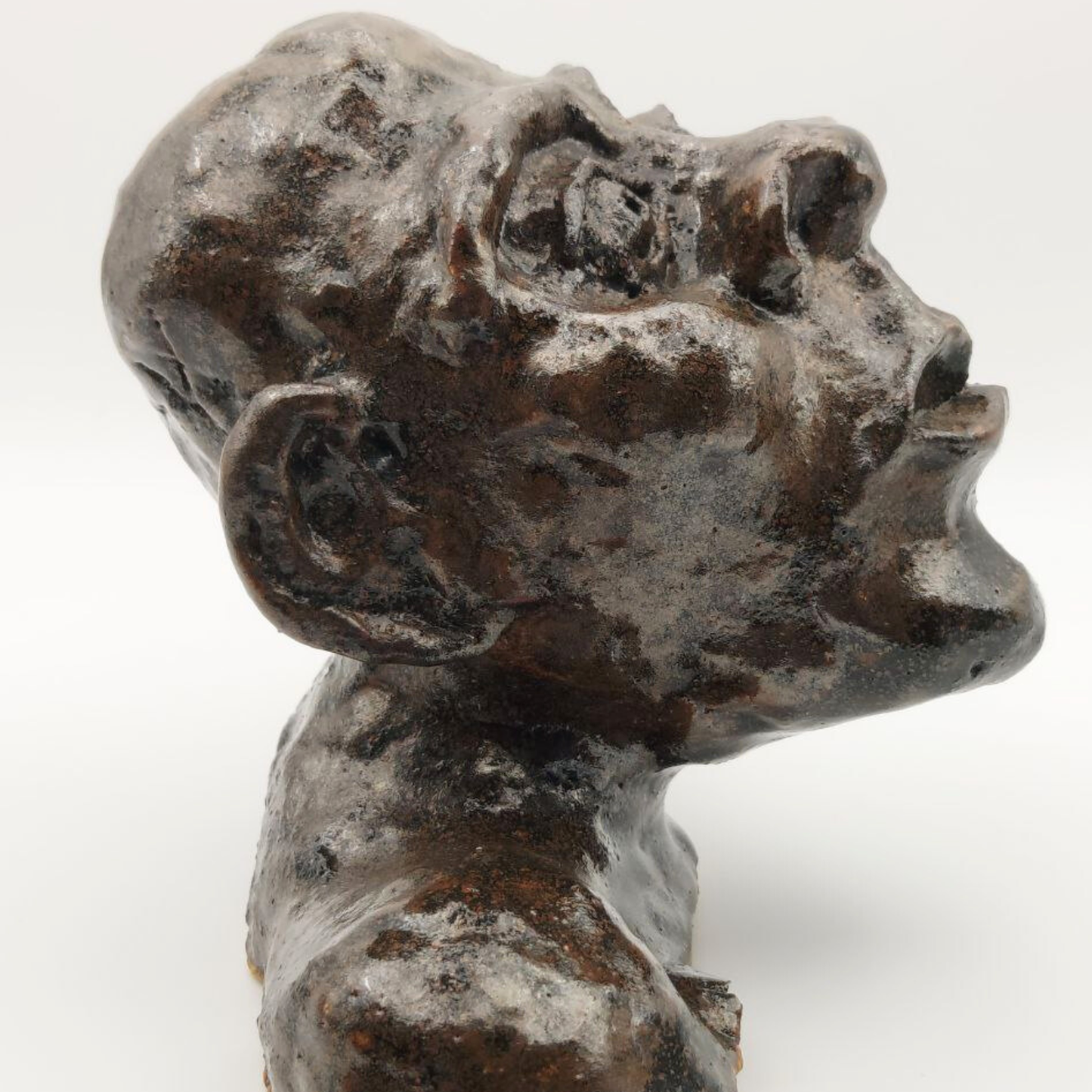 Ceramic bust against a white background - side-on view. 