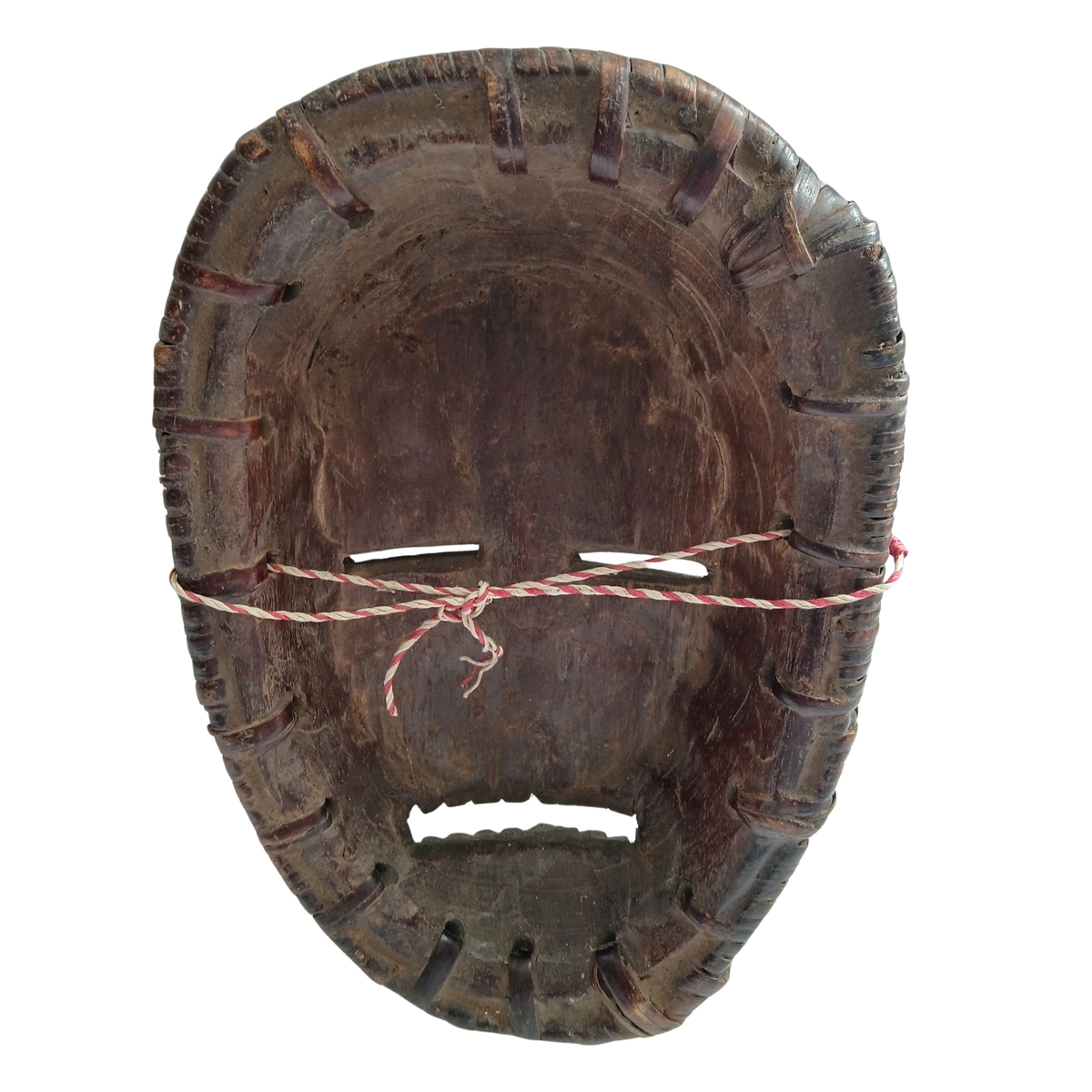 A dark brown carved wooden mask with a red and white striped cord tied around the eye area, shown against a plain white background.