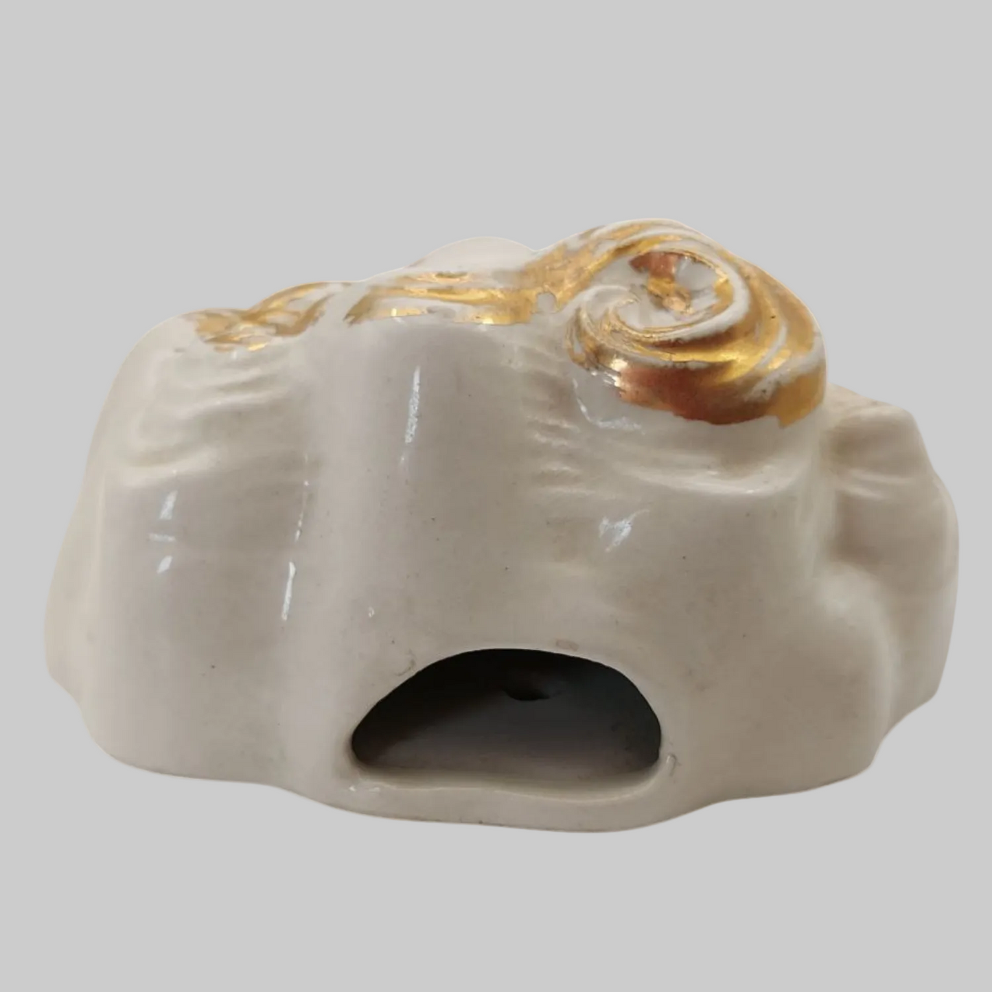 Chalkware mask with gold accents on a white background