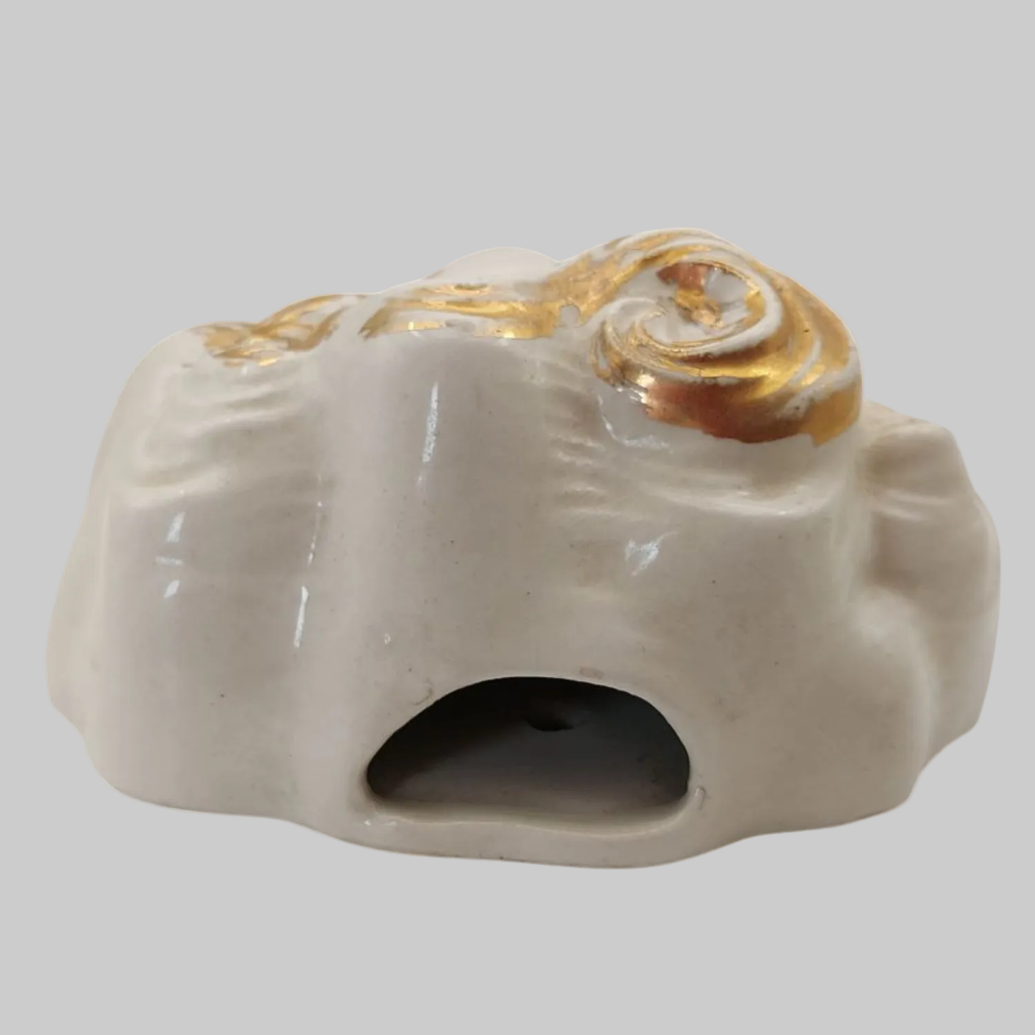 Chalkware mask with gold accents on a white background