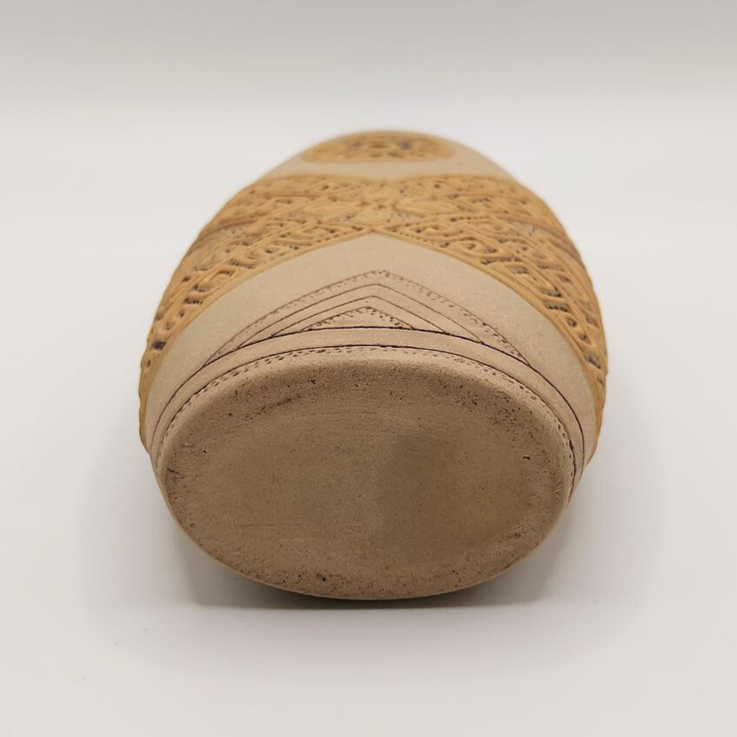 Base of a small vase with woven pattern on a white background