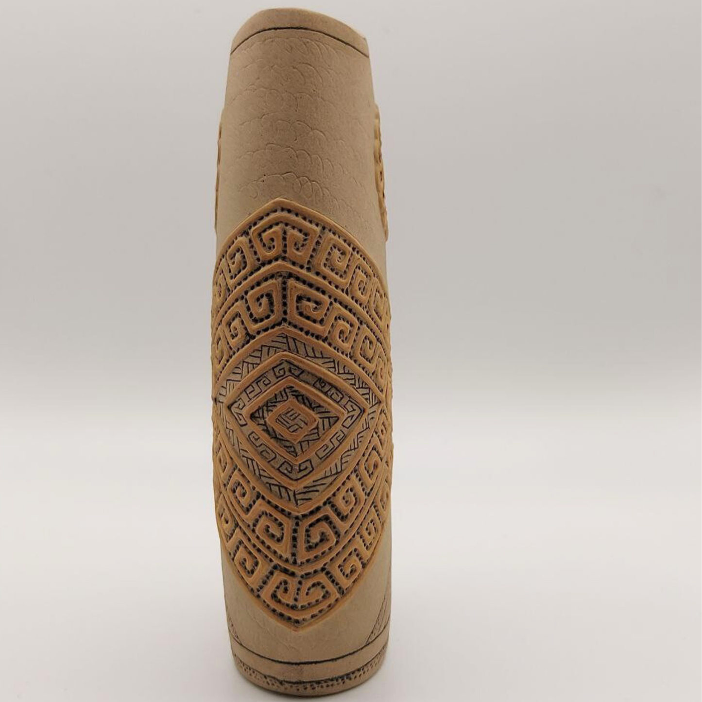 Brown textured studio pottery vase with geometric patterns on a white background