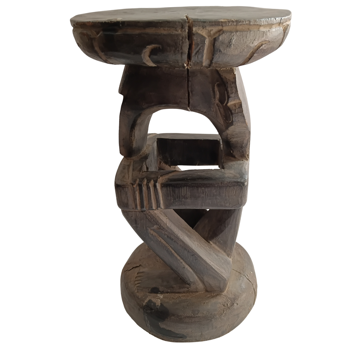 A rustic carved wooden stool with a round seat and a sculptural, twisted base on a plain white background.