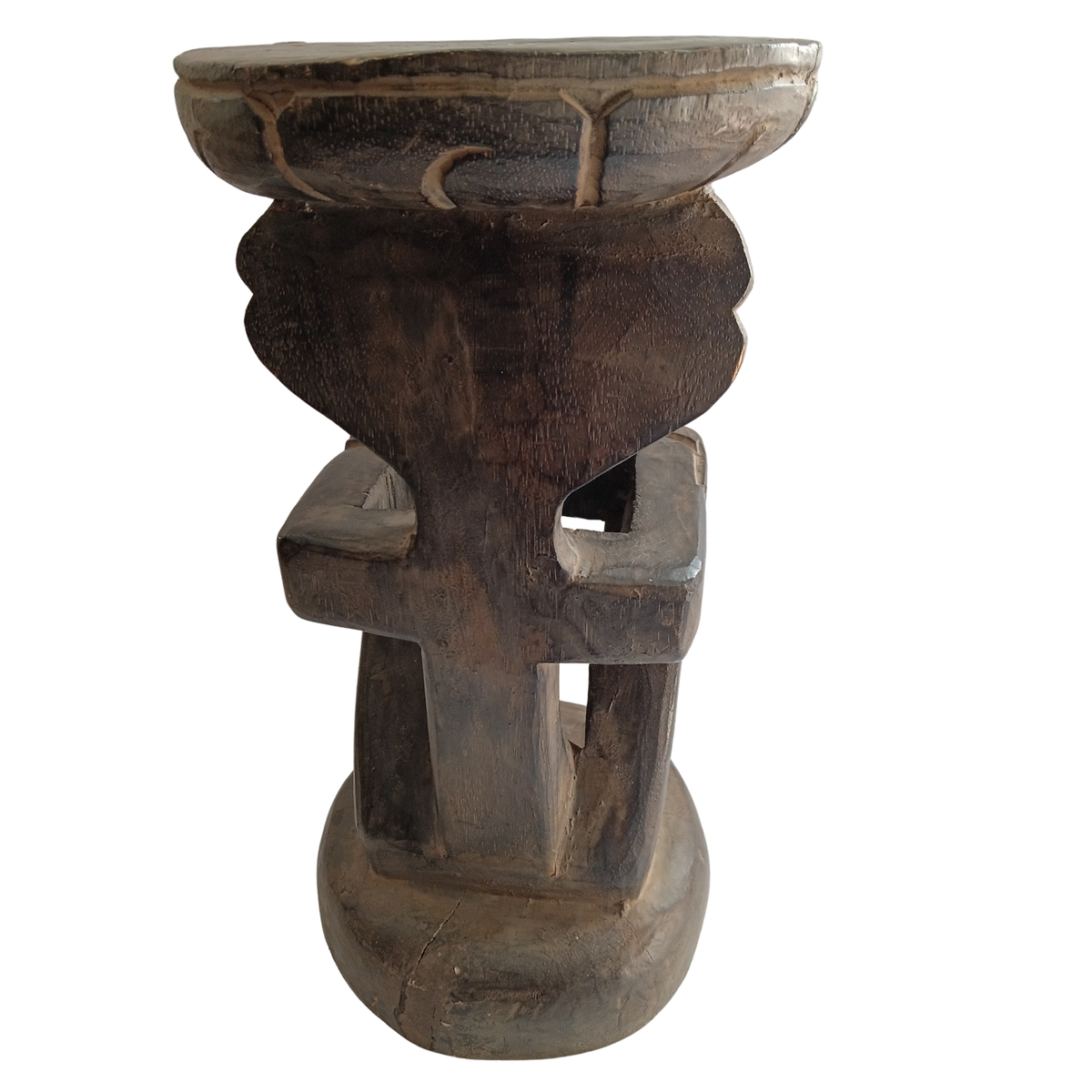 A dark carved wooden pedestal stool with a round bowl-like top and cutout legs, shown against a plain white background.