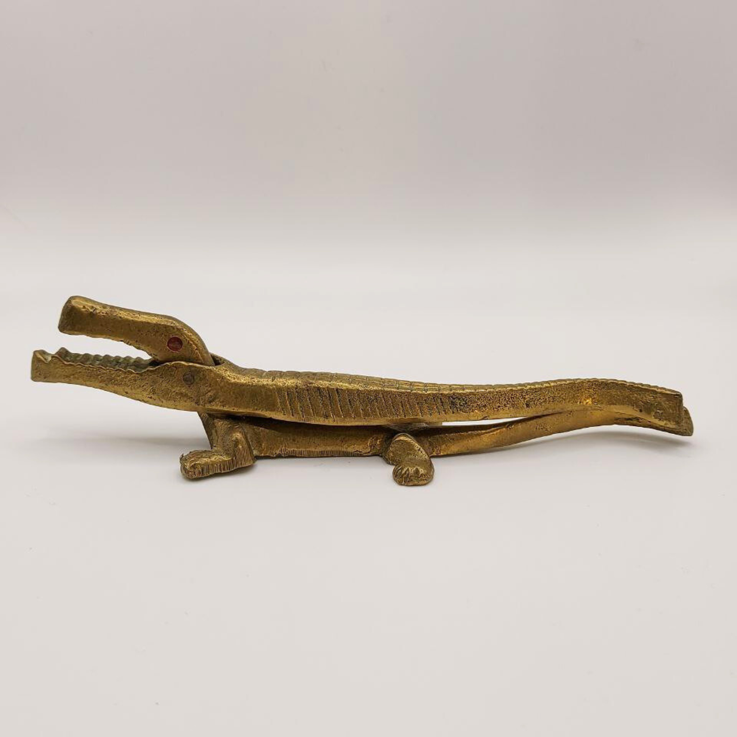 Bronze alligator-shapednucracker on a white background