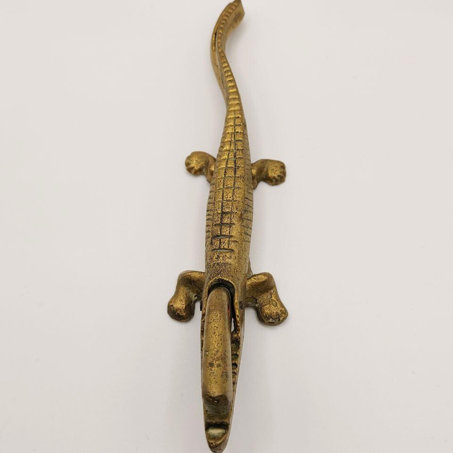 Bronze alligator-shaped nutcracker on a white background