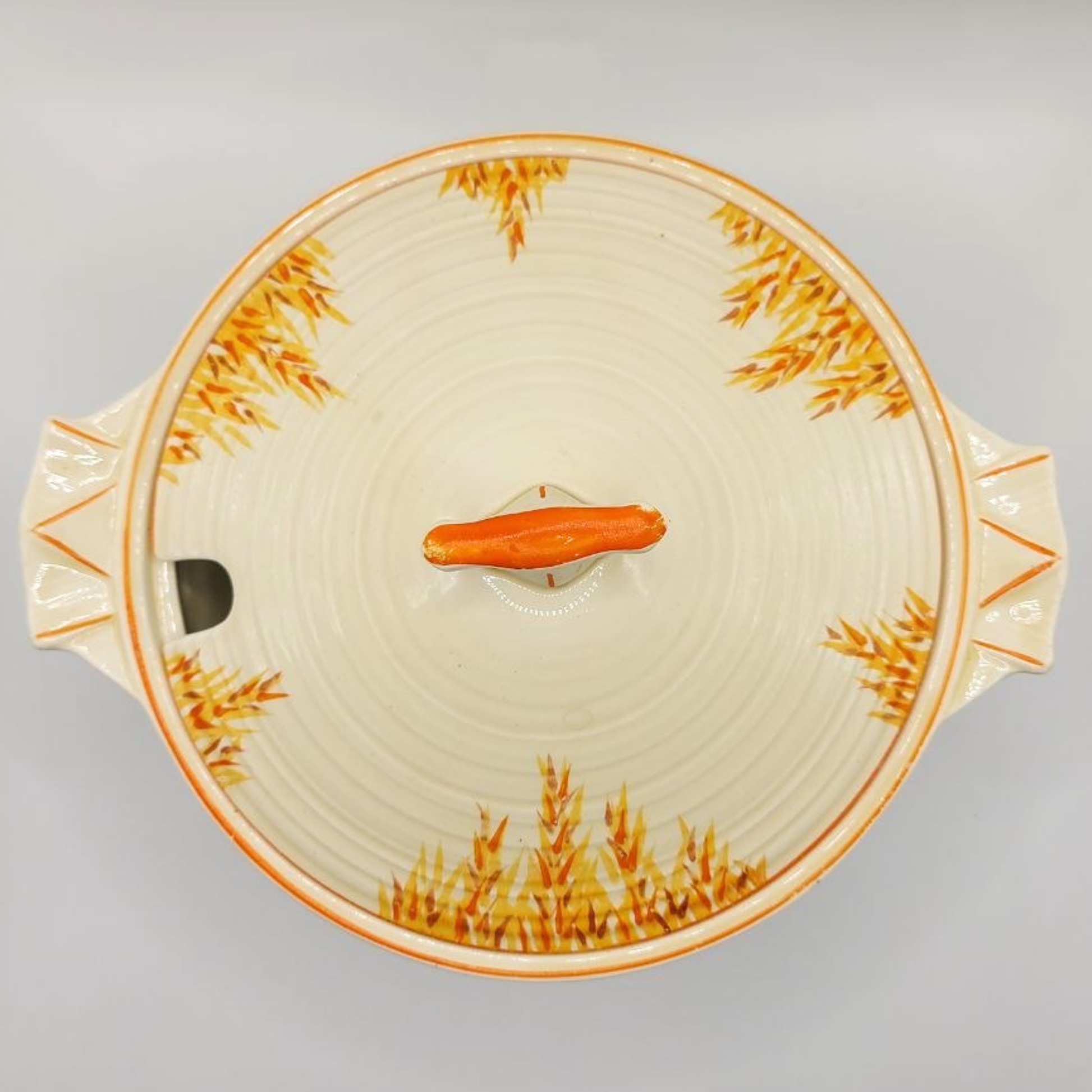 Decorative ceramic dish with wheat patterns on a grey background