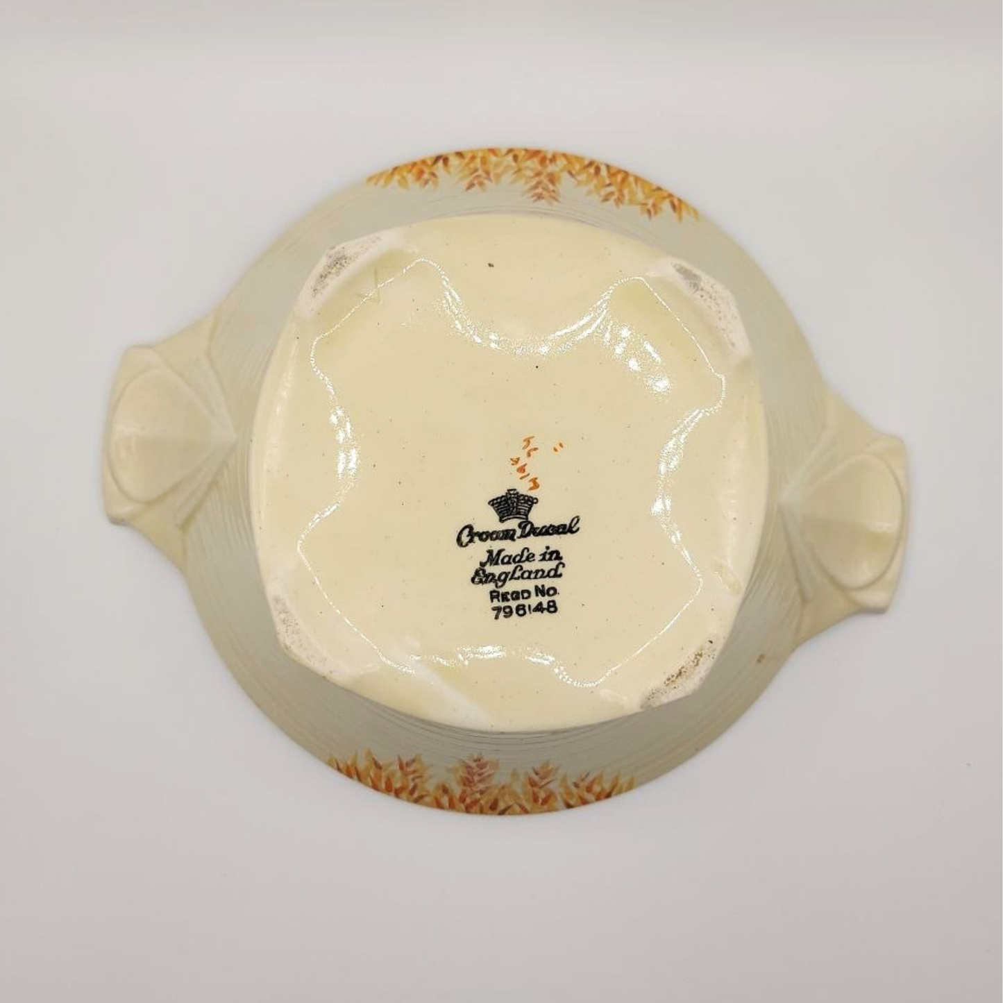 Decorative ceramic bowl with wheat patterns on a plain background