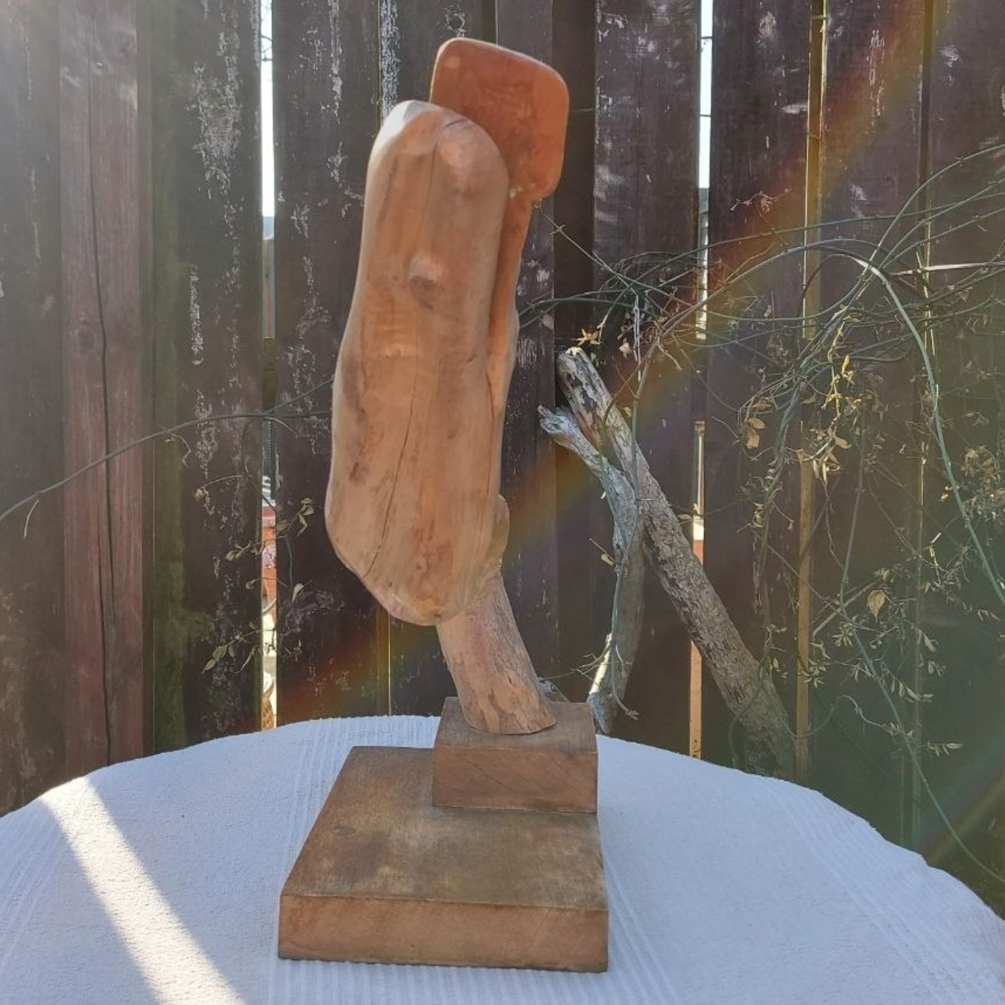 Wooden sculpture on a stand with a natural background