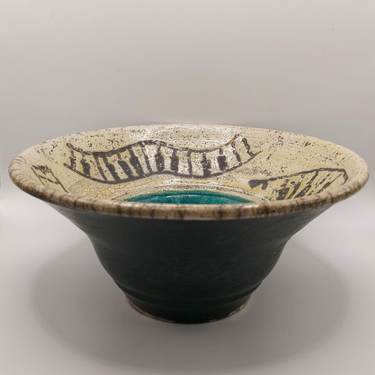 Earthenware pottery bowl with decorative rim on a gray background