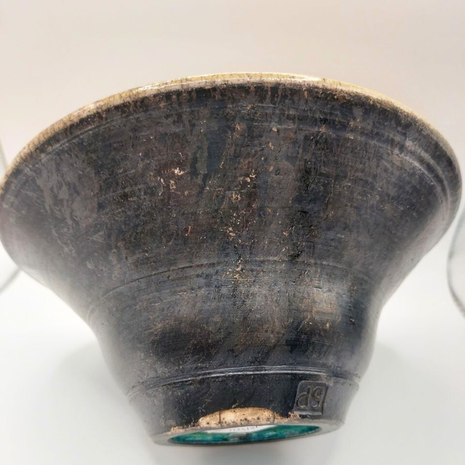 Black ceramic bowl with visible wear on a white background