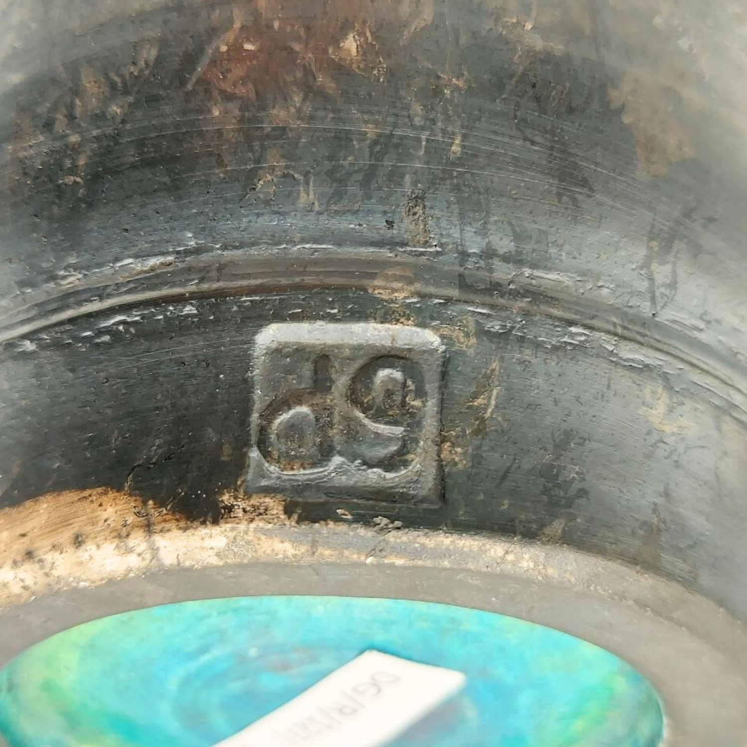 Close-up of a pottery bowl signature with the initials "dg"