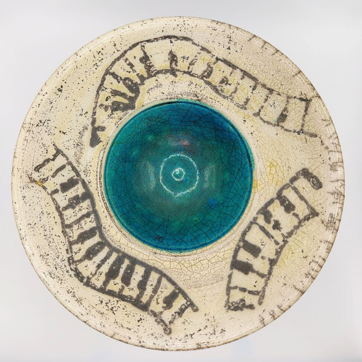 Earthenware pottery dish with blue center and black line patterns on a white background