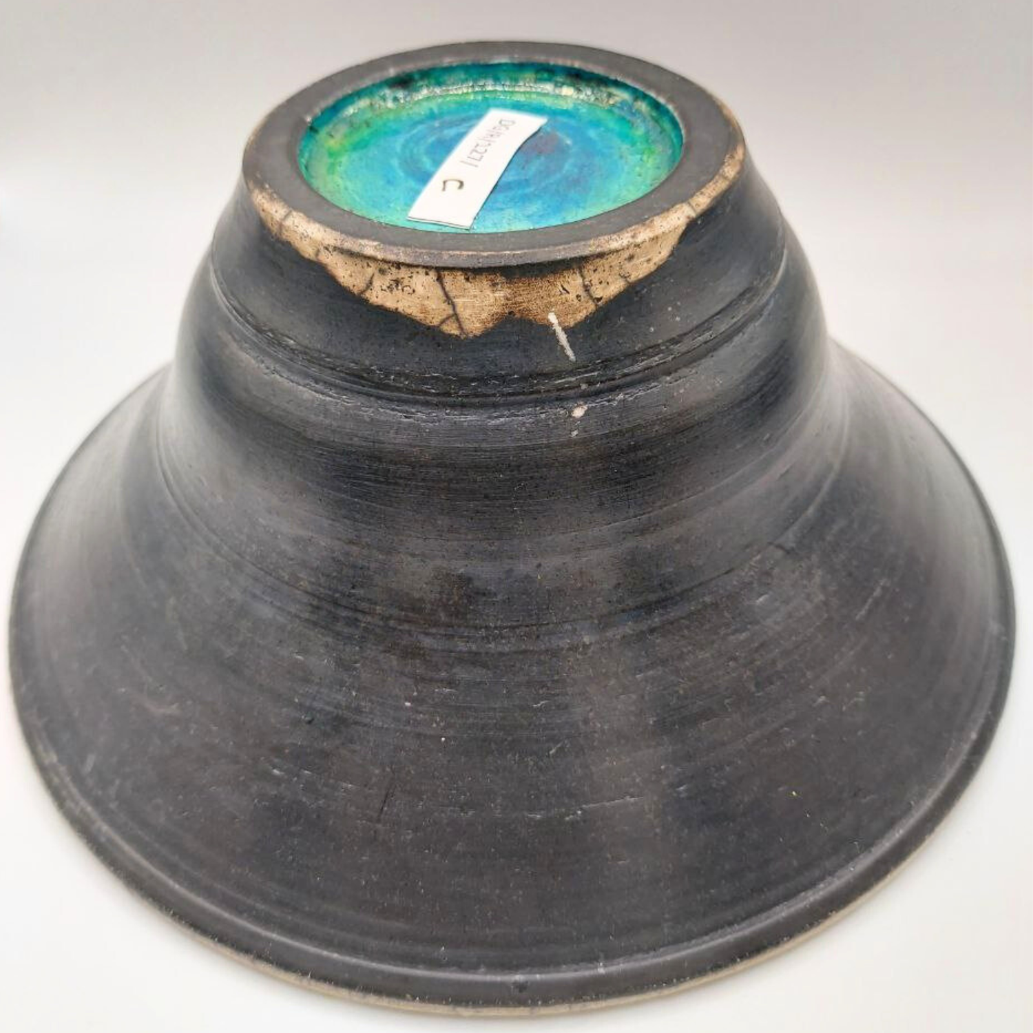 Black ceramic bowl with a textured surface on a white background
