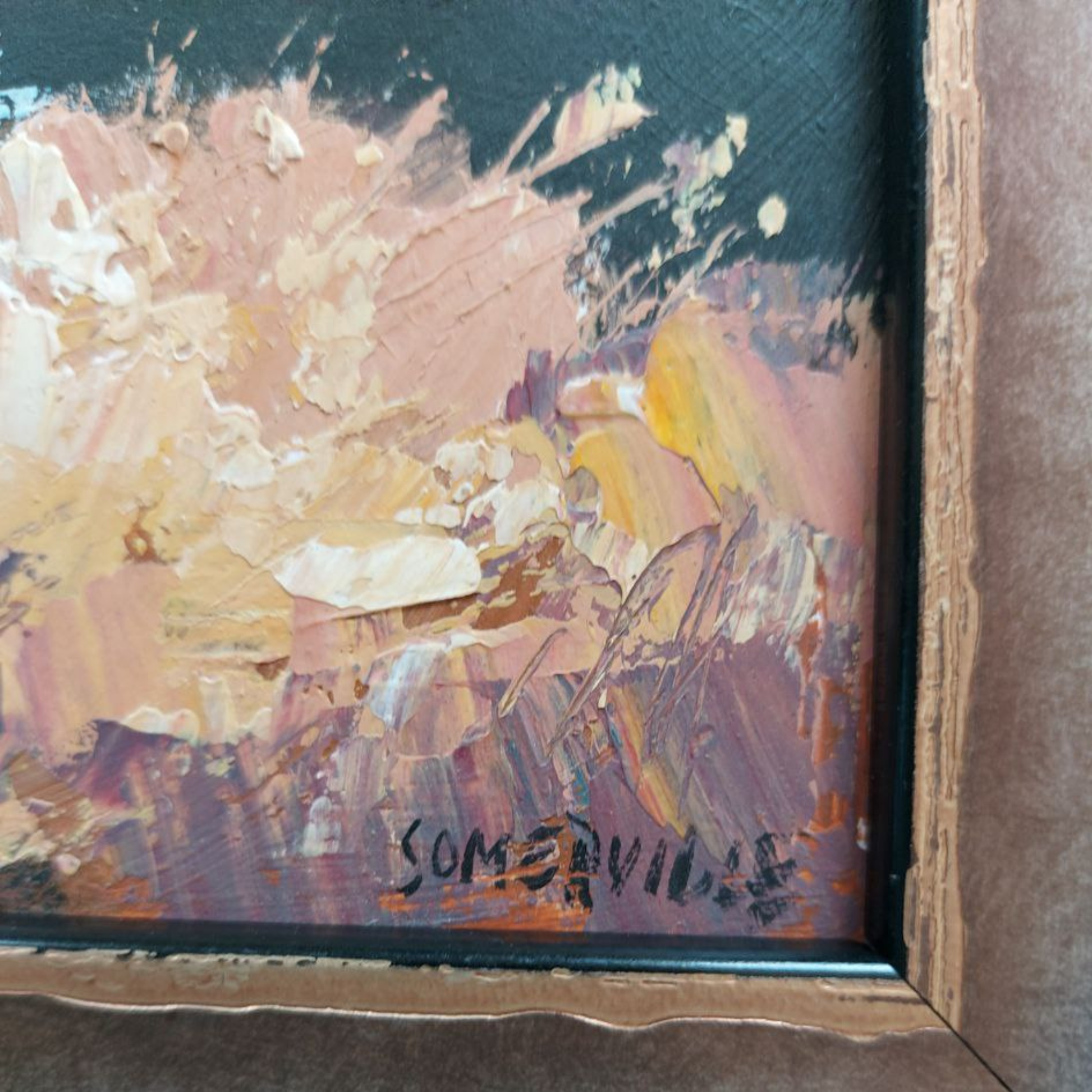 Abstract painting with splashes of pink, yellow, and purple in a wooden frame.