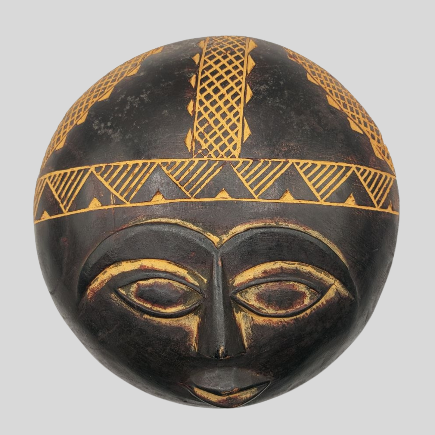 Black and gold decorative mask on a grey background