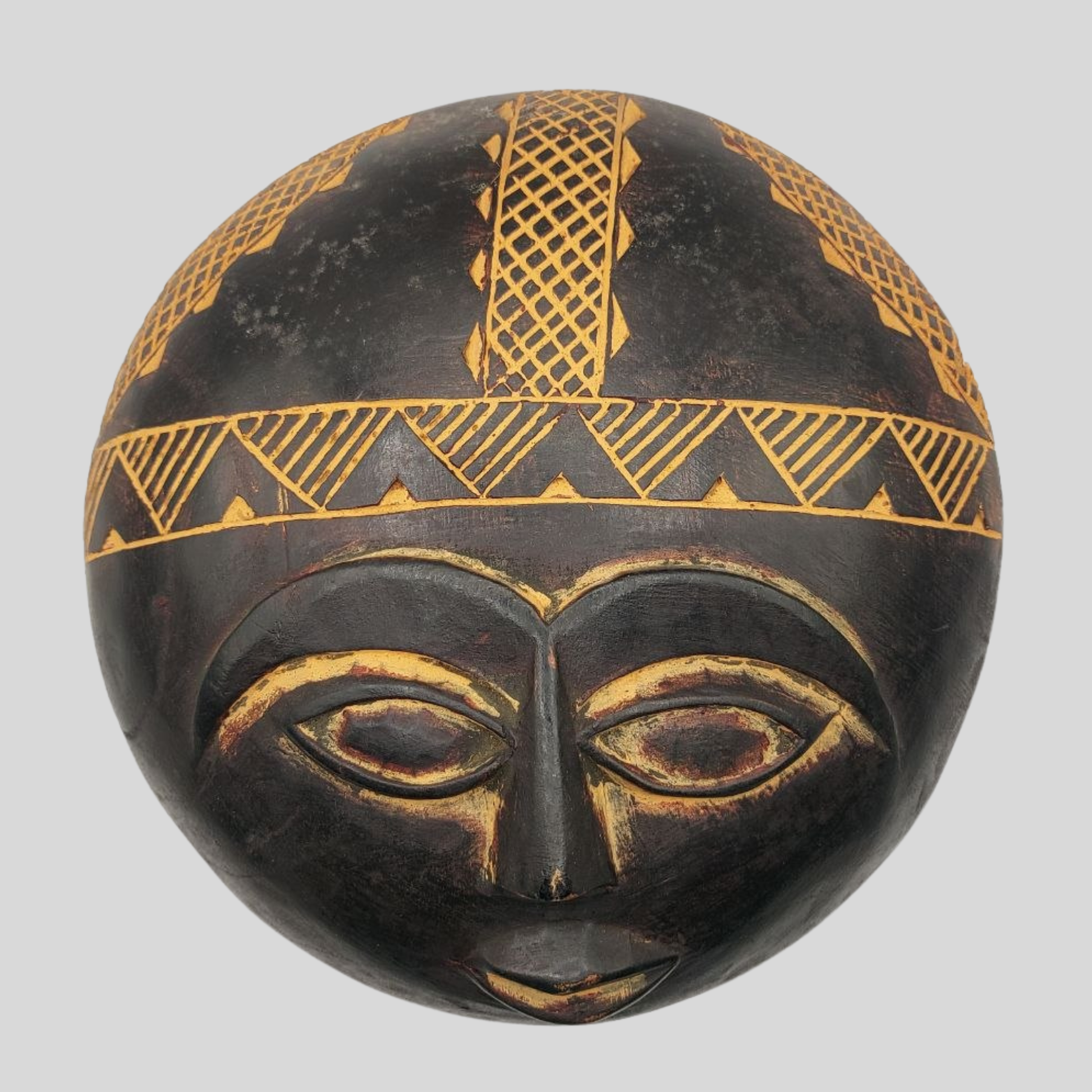 Black and gold decorative mask on a grey background