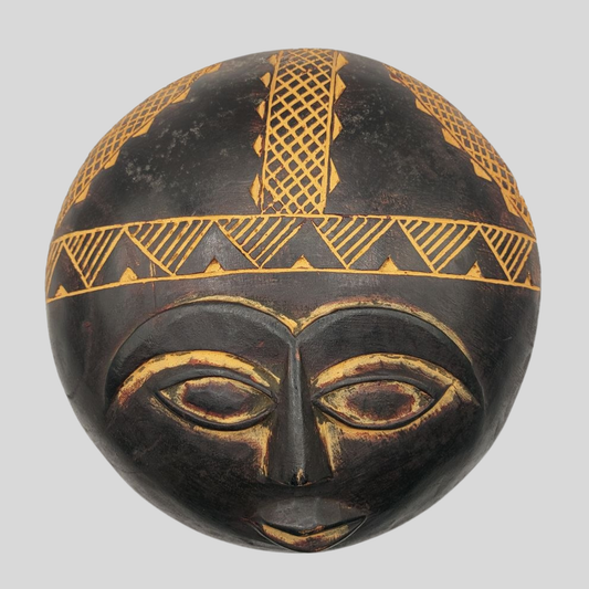 Black and gold decorative mask on a grey background