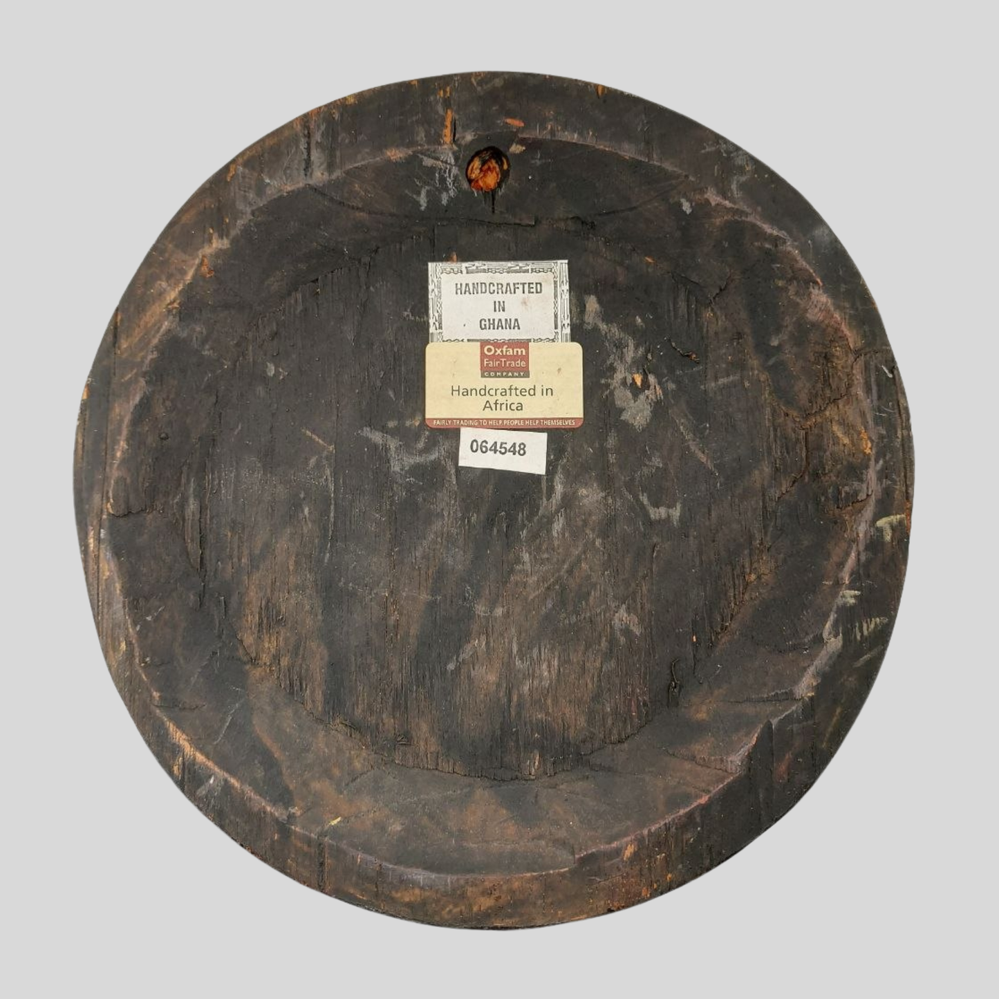 Round wooden mask with an Oxfam FairTrade label. 