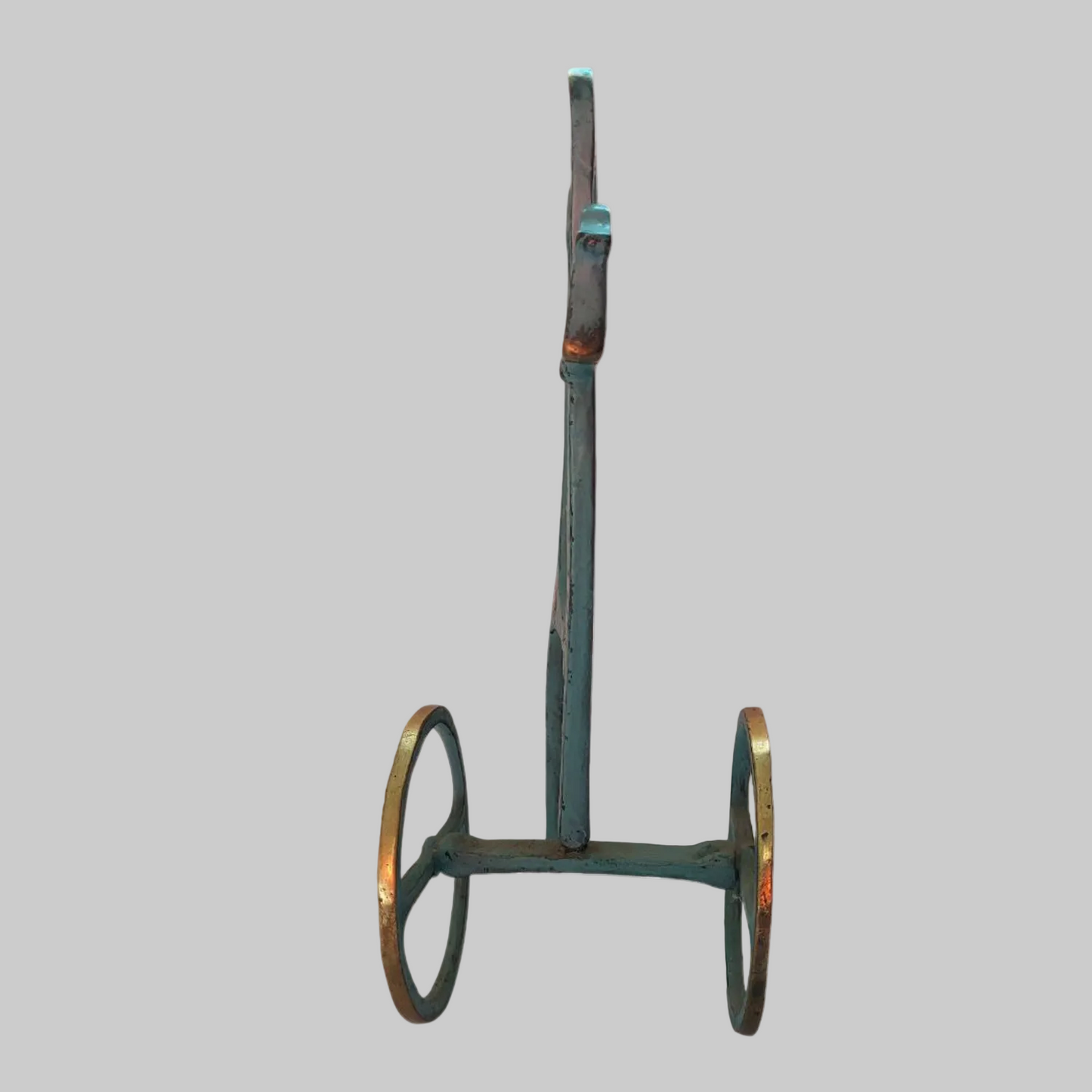 Metal horse sculpture with wheels on a white background