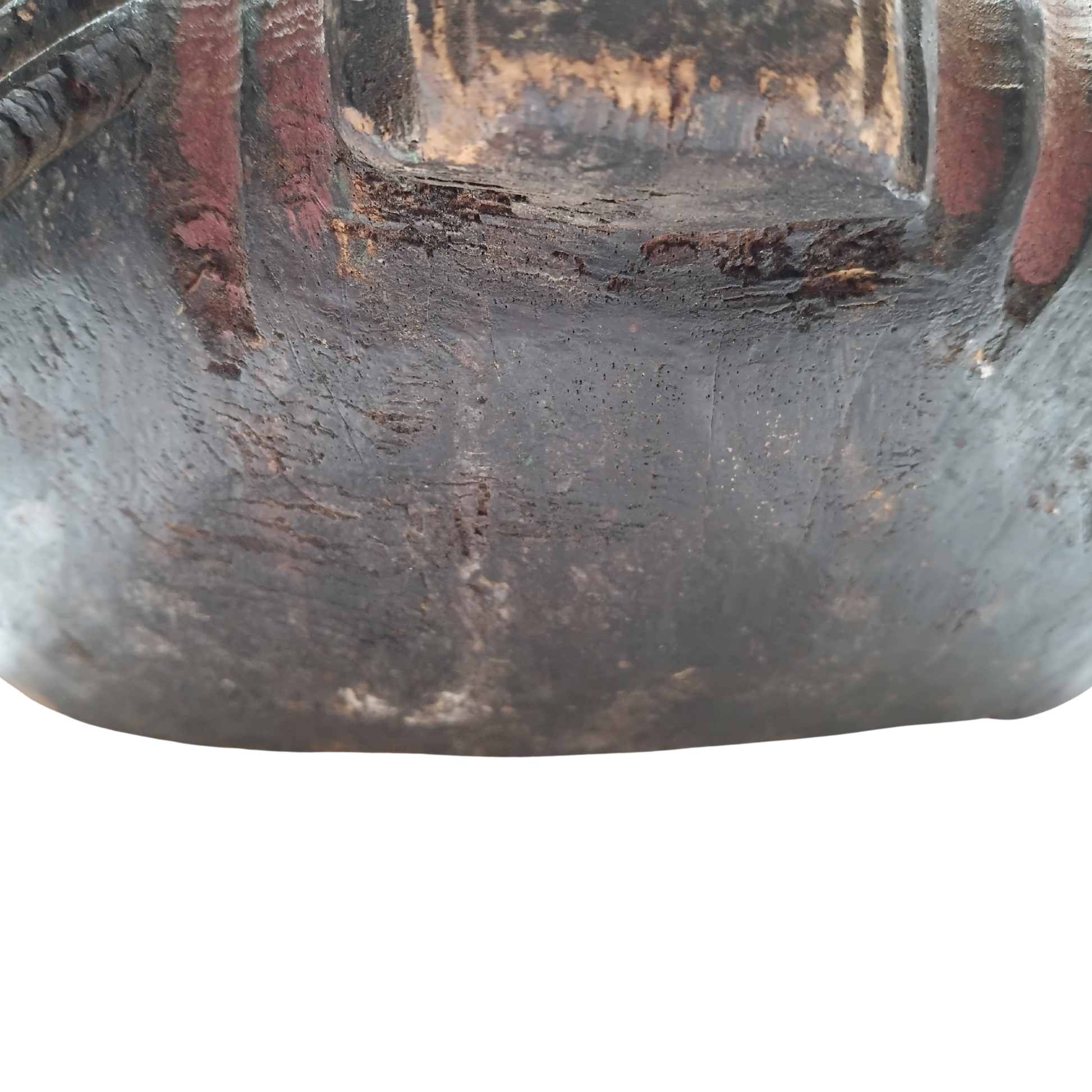 Close-up of a dark, heavily textured mask with reddish-brown vertical accents and a glossy finish, isolated on a white background.