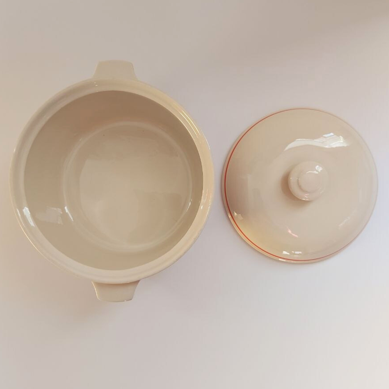 Beige ceramic dish with lid on a white background