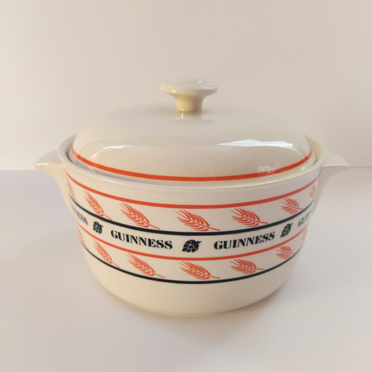 Beige ceramic pot with red and black Guinness logo on a white background