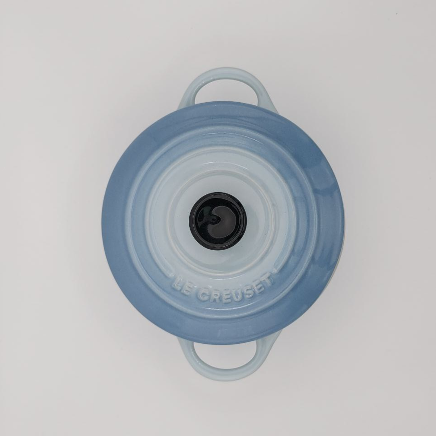 Blue cooking pot lid with handles on a white background