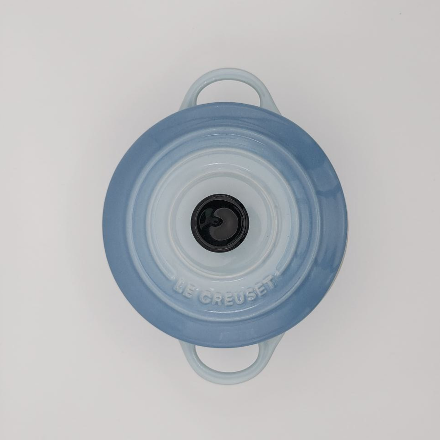Blue cooking pot lid with handles on a white background
