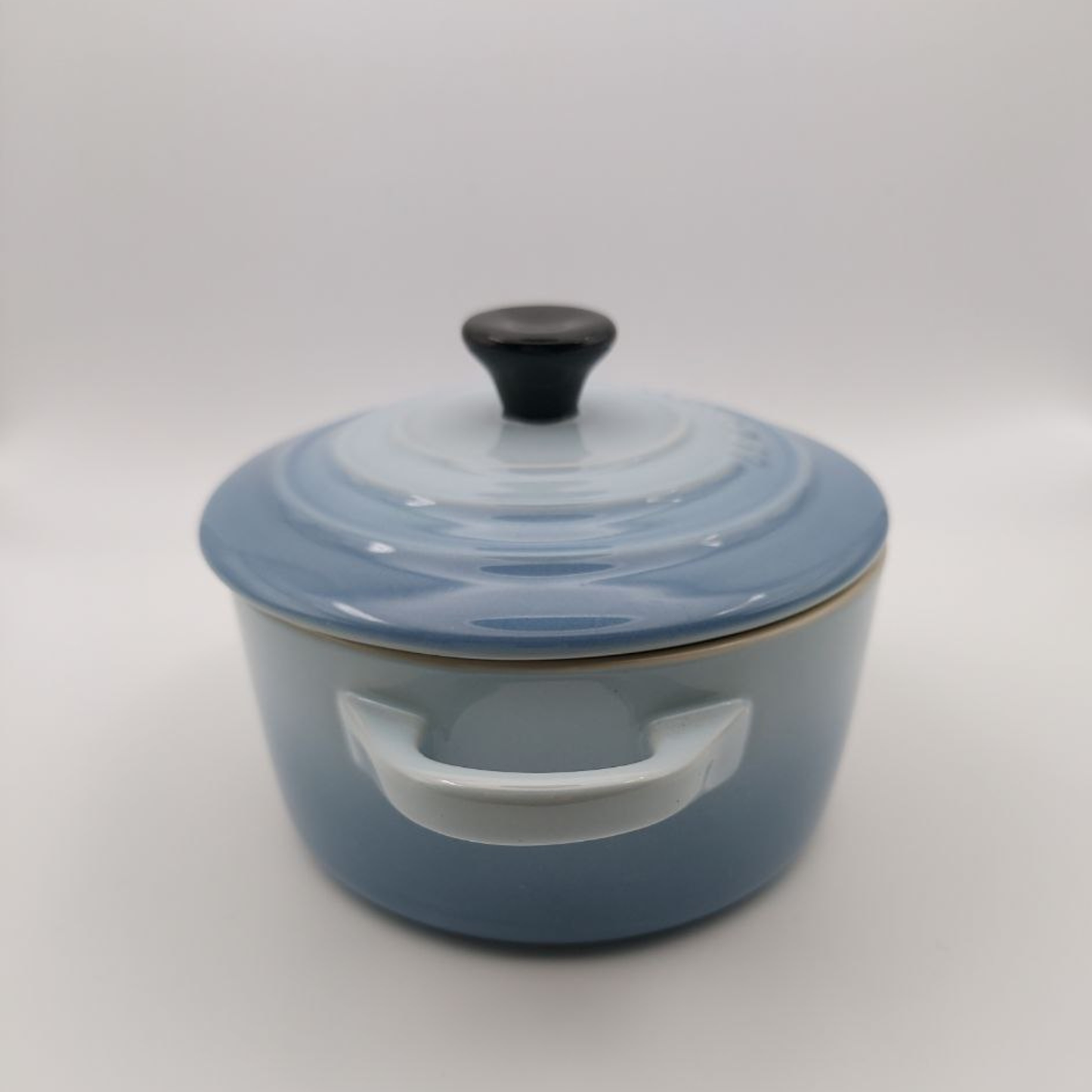 Blue stoneware cooking pot with lid on a white background