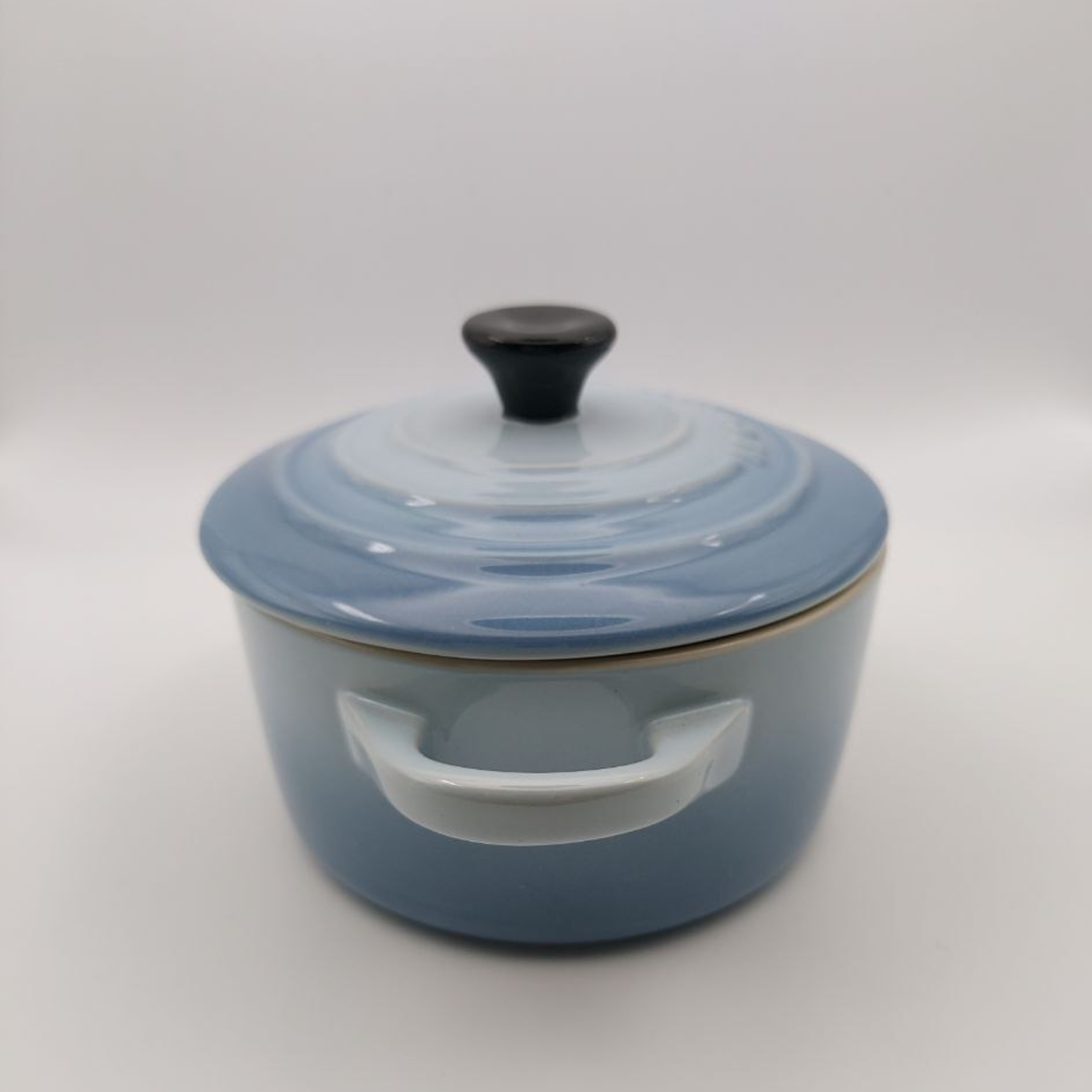 Blue stoneware cooking pot with lid on a white background
